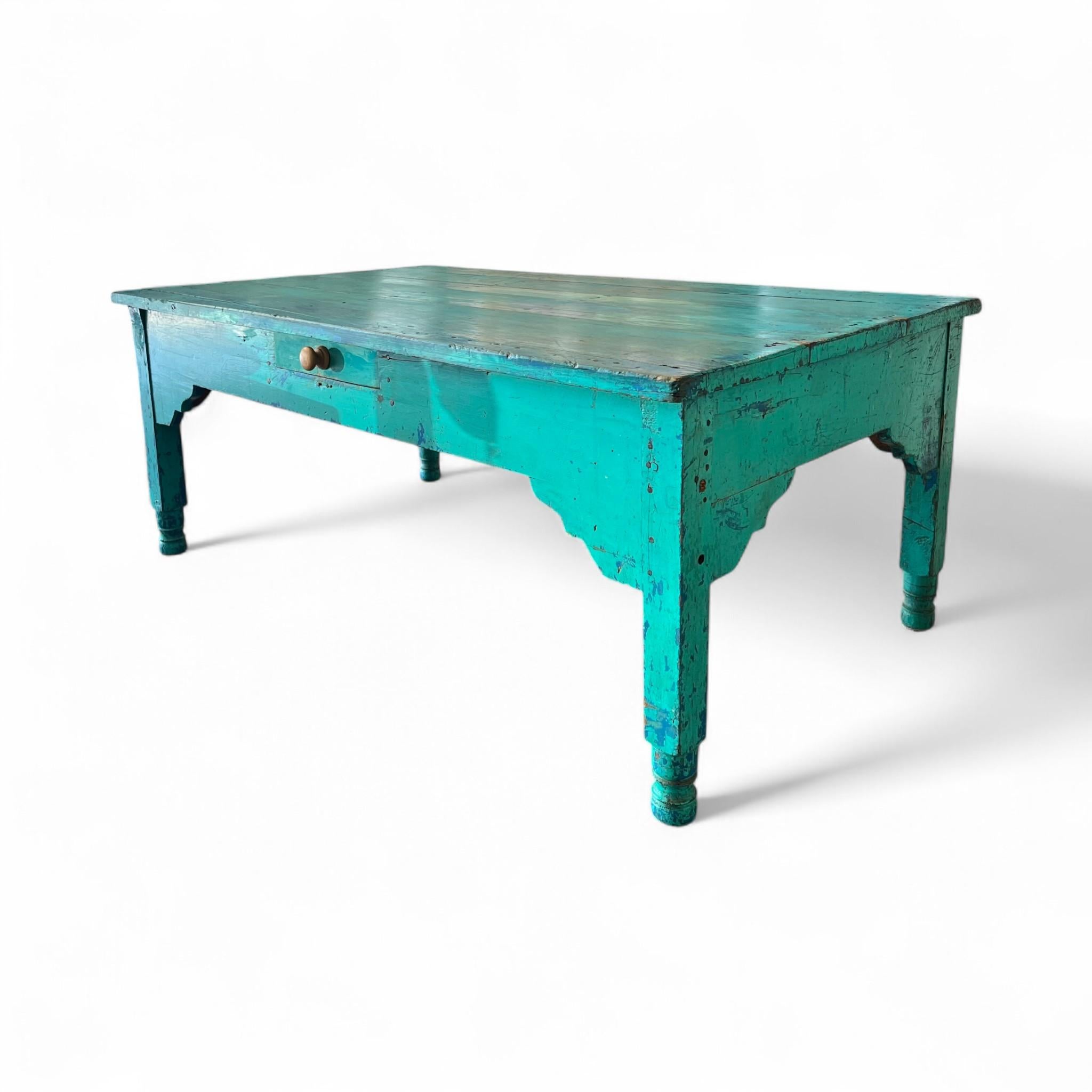 Esta vibrante mesa de centro turquesa de granja aporta un atrevido estallido de color a cualquier espacio. Con un acabado envejecido, patas torneadas y un único cajón central, combina el encanto rústico con el almacenamiento práctico. Perfecto para