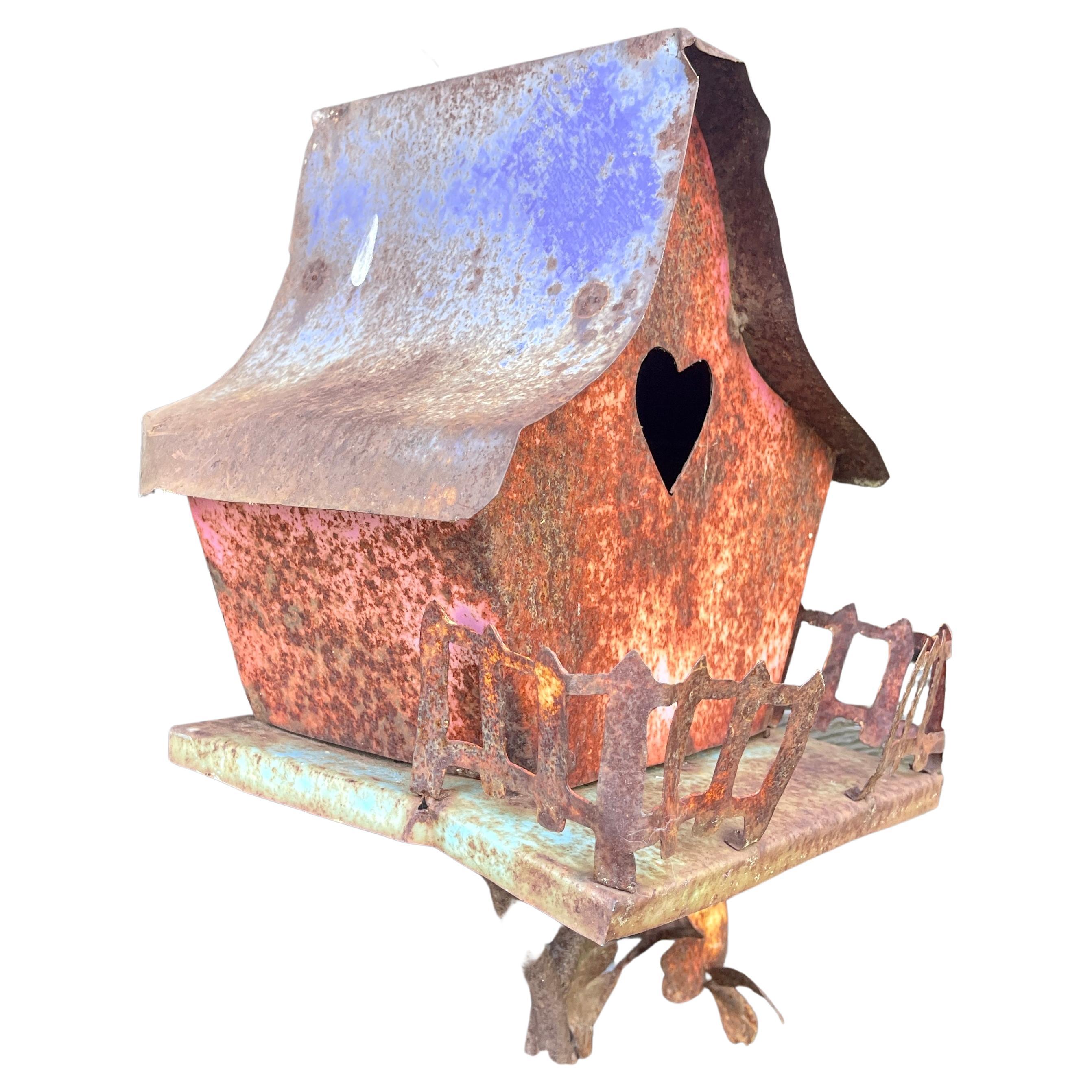Charming One of a Kind Iron Bird House Feeding With a Heart as Window.
The bird feeder is in its original paint and patina. The house has a rear door in working condition, that functions as access to the house for the bird seeds.