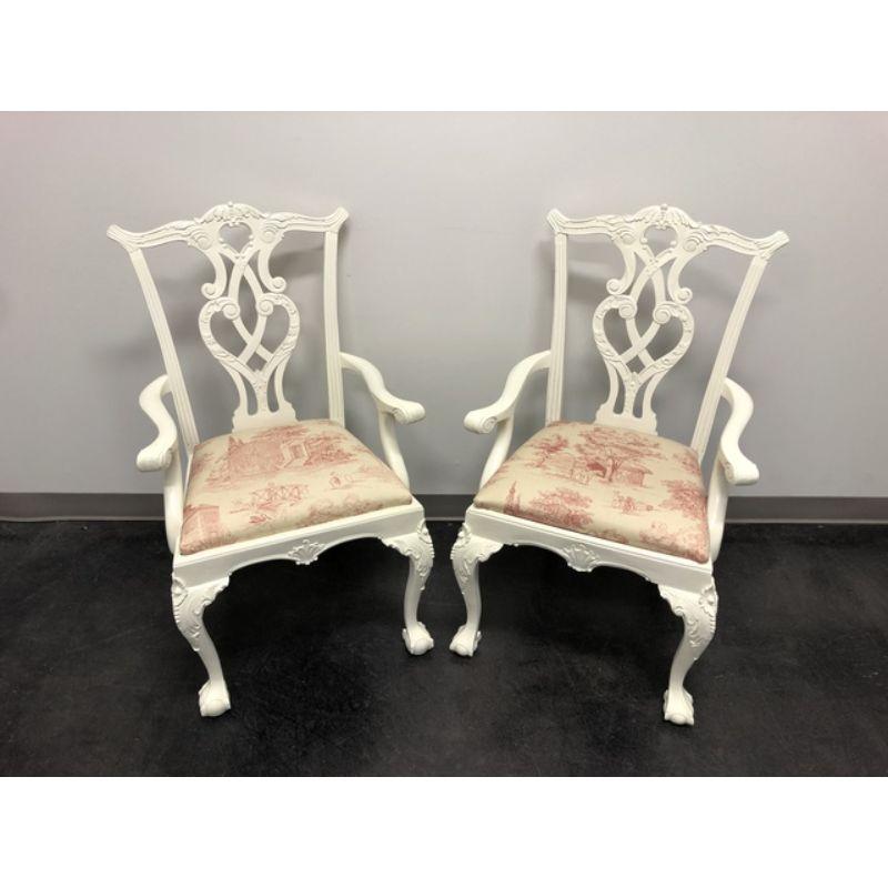 A pair of Chippendale style armchairs in solid mahogany, freshly painted in ivory with pink farm motif upholstery. Intricately carved backsplats, knees and aprons, ball in claw feet.

Measures: Overall: 25 W 23.5 D 41 H, Seats: 18 W 16 D 20.5 H,