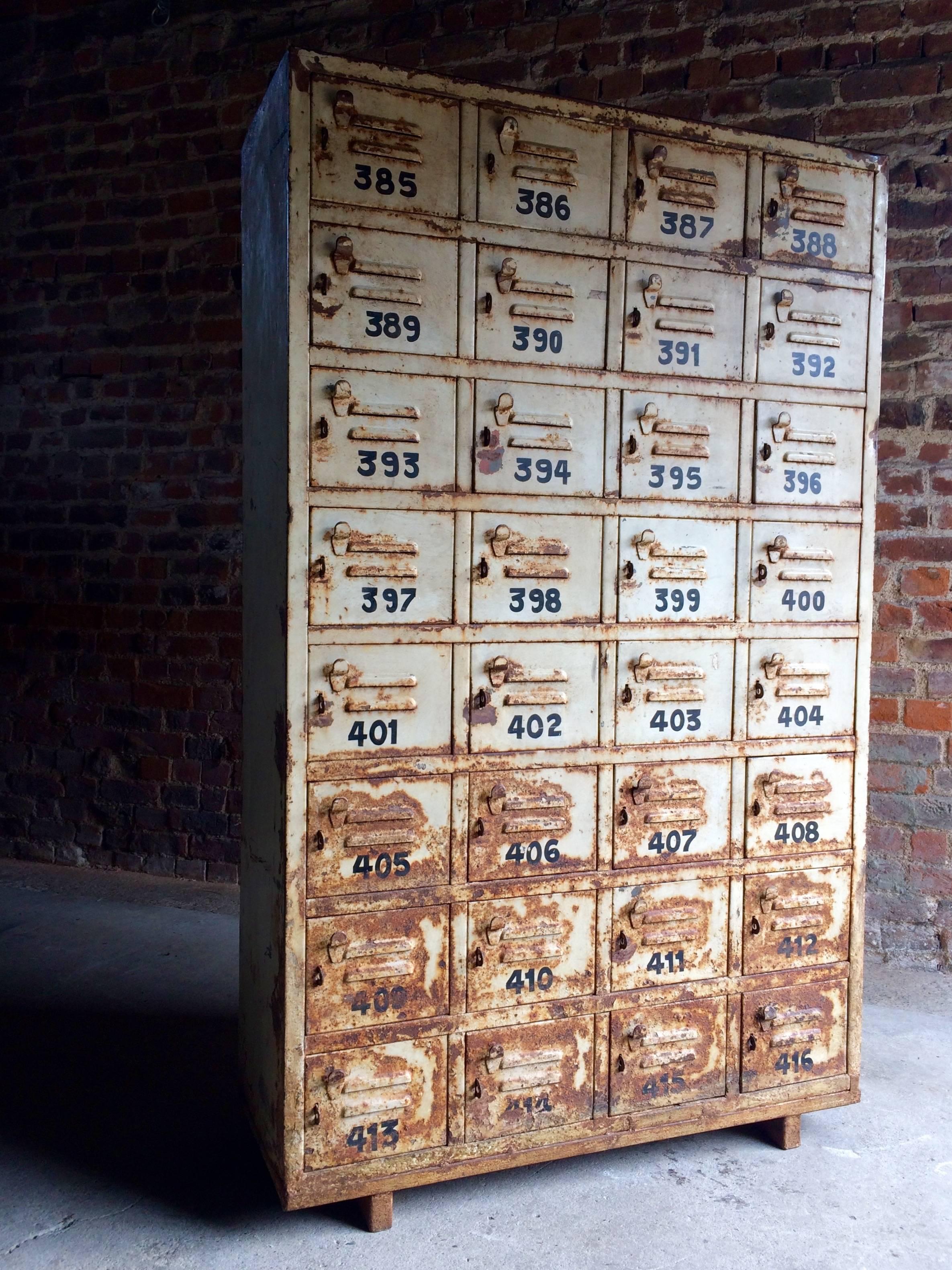 A stunning large vintage painted metal industrial cabinet. The cabinet having a total of thirty two numbered fitted lockers, standing on four block feet, looks amazing.