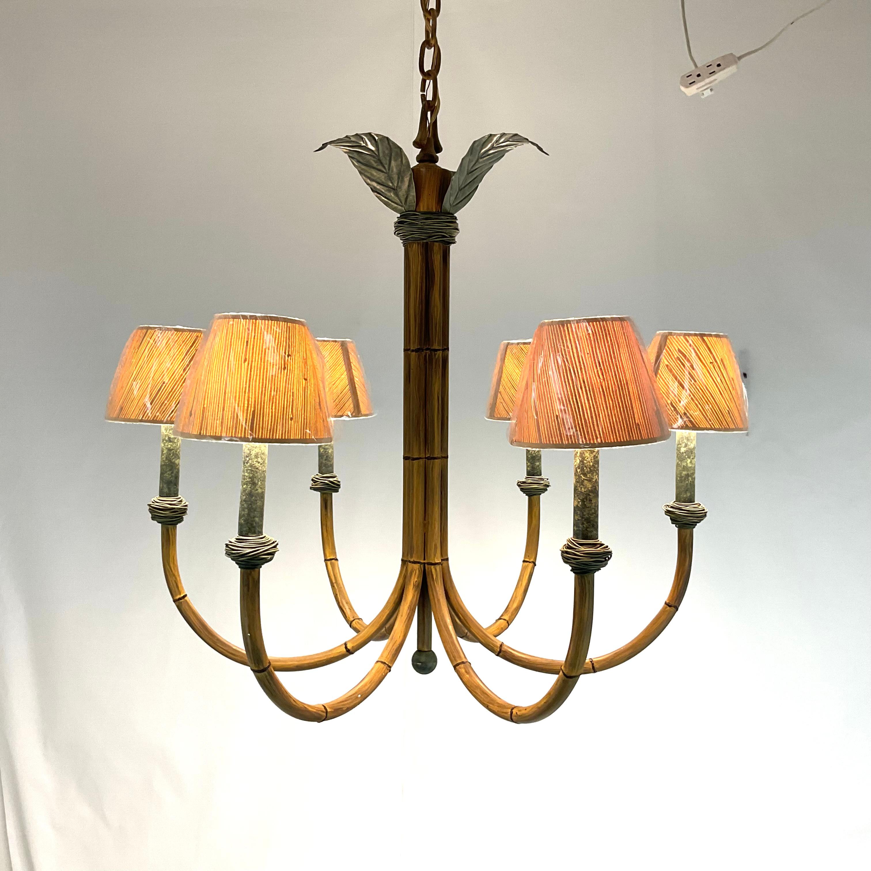 Questo lampadario di grande impatto unisce il fascino della natura a un design raffinato, con una struttura ispirata al bambù accentuata da dettagli in metallo verde verdastro. Sei bracci graziosamente curvi si estendono verso l'esterno, ognuno dei
