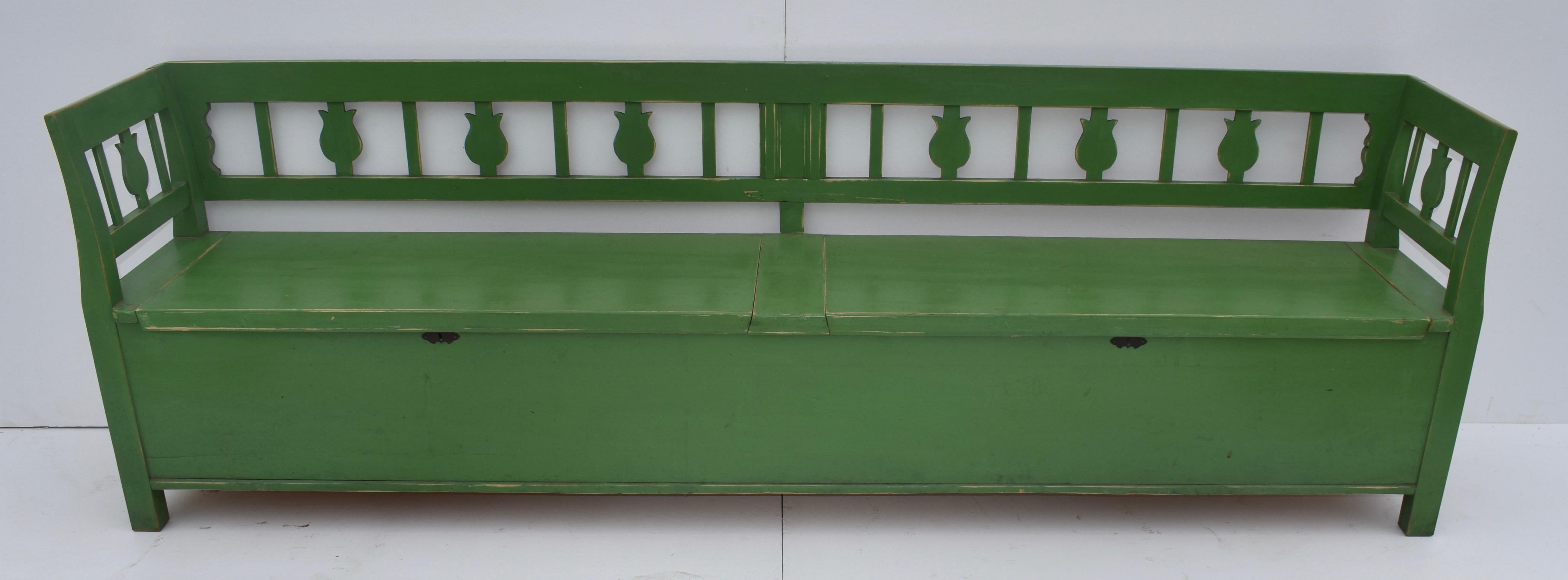 This is a copy of the characteristic Central European 19th century box bench, probably made in the fifties, and is certainly among the longest we have seen. The straight back rails are divided by a central splat with alternating slats and cutout