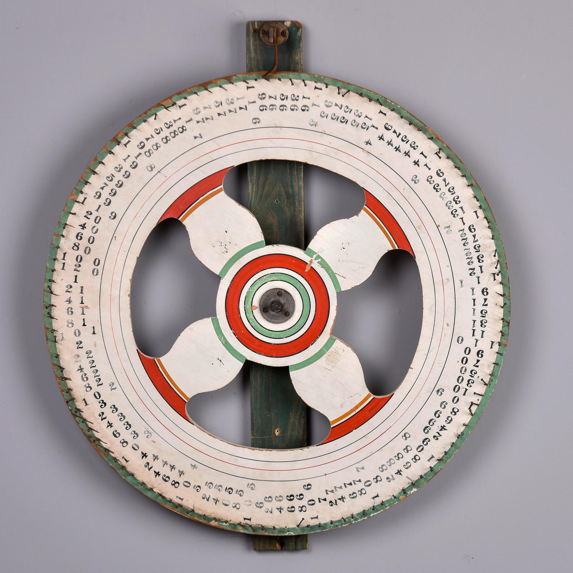 Found in the US, this painted wood carnival game wheel dates from the late 1940s/early 1950s. Wood wheel has colorful painted details and numbers separated by nails. The original leather number ticker at the top is still attached and this wheel
