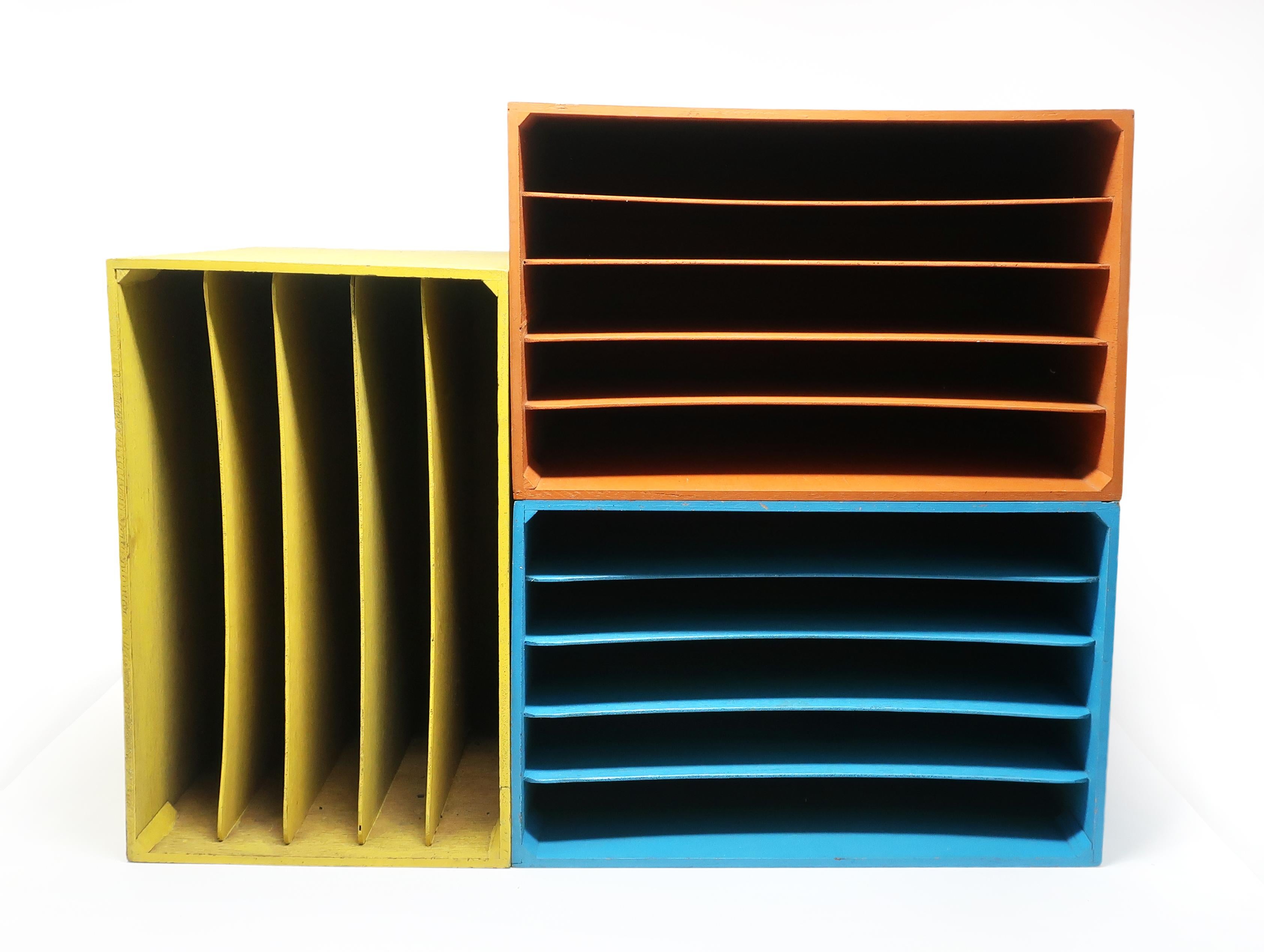 A set of three painted wooden boxes with divided slots in blue, yellow and orange. Can be used separately, set side by side, or stacked on top of each other. Perfect for storing vinyl records or magazines, or can be used to organize papers or files.
