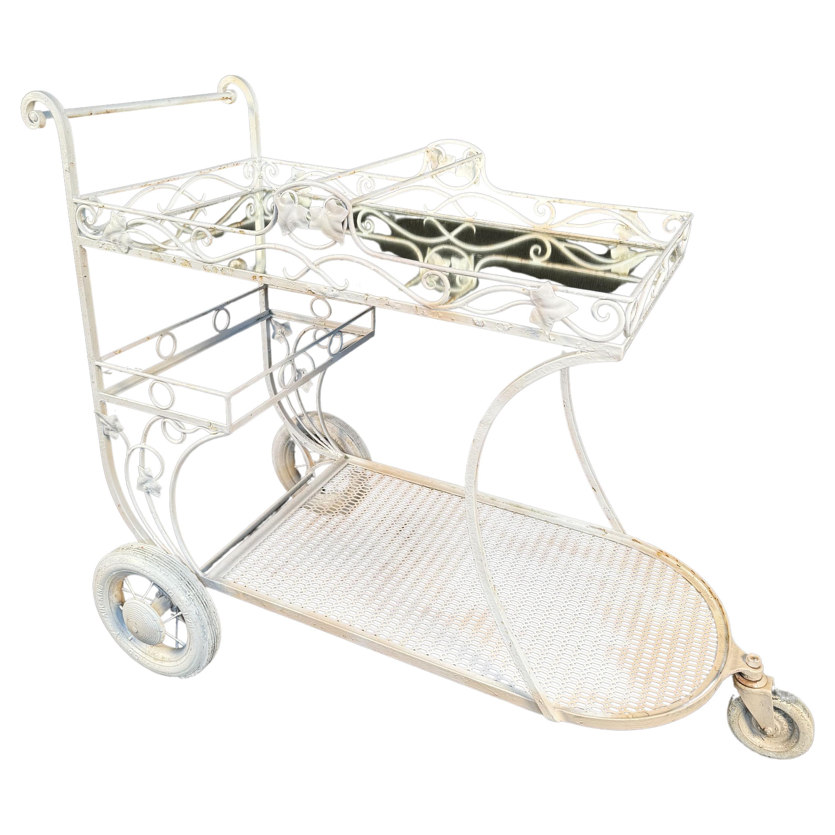 Chariot de jardin vintage en fer forgé peint. Elle est dotée d'une structure métallique florale, d'un plateau en verre miroir et de grandes roues. Veuillez confirmer la localisation avec le vendeur (NY ou NJ)