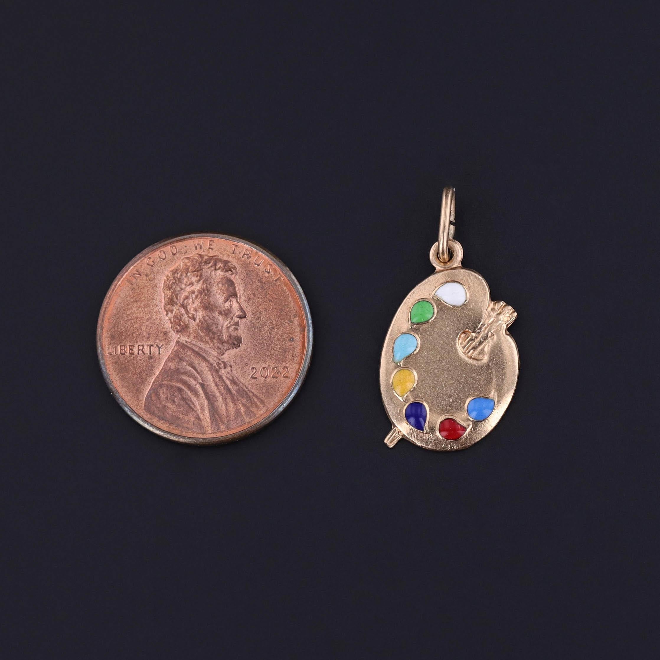 A vintage charm from the 1960s featuring a 14k gold painter's palette with colorful enamel 'swatches'.

The piece measures 0.9 inches from the top of the jump ring to bottom by 0.5 inches wide and weighs 2.19 grams. It is in great
