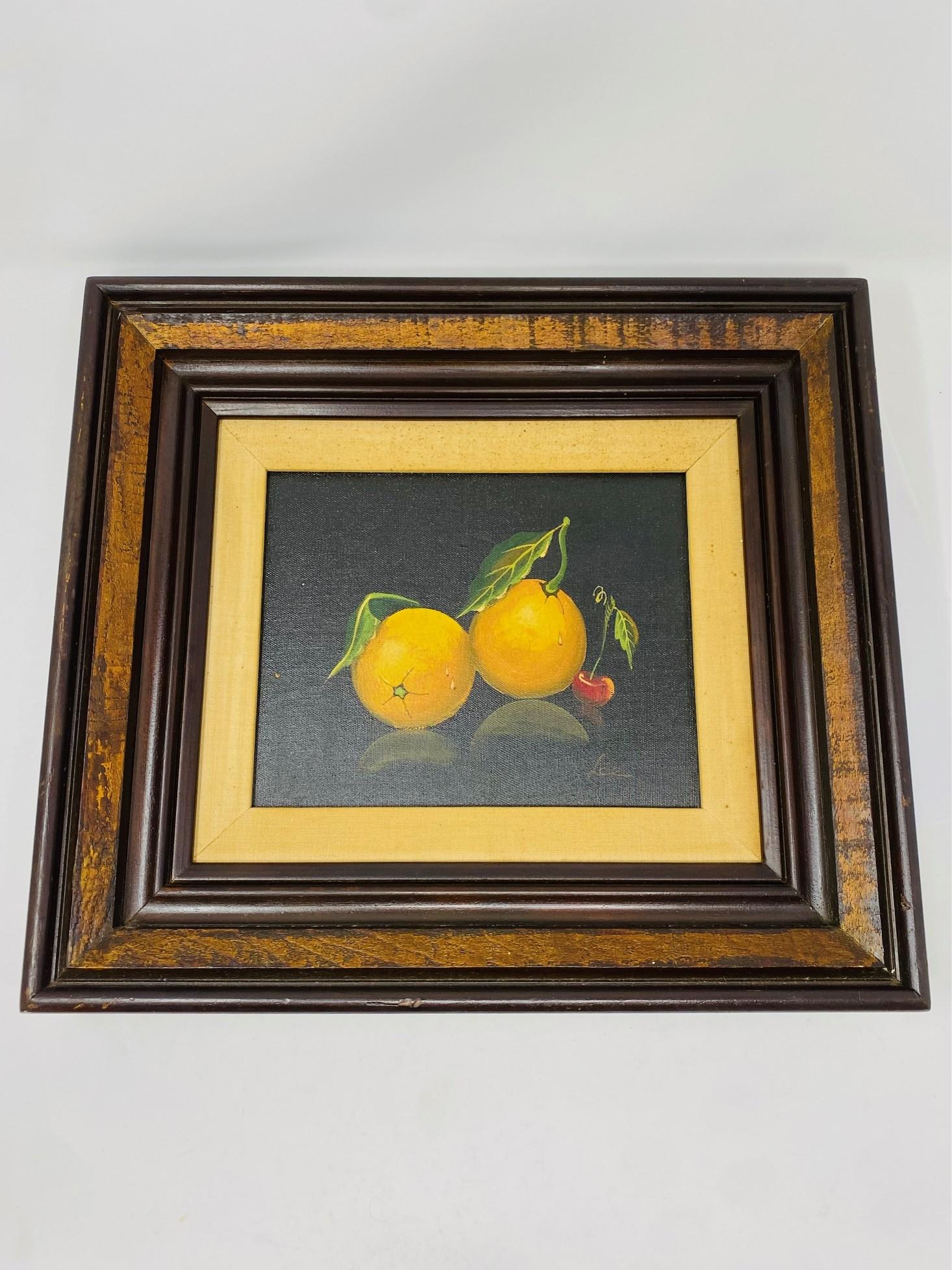 La peinture à l'huile sur toile représente majestueusement une paire d'oranges sur une vigne avec une feuille, ainsi qu'une cerise adjacente. La scène est représentée sur un fond sombre, mais l'artiste a utilisé une technique intrigante dans