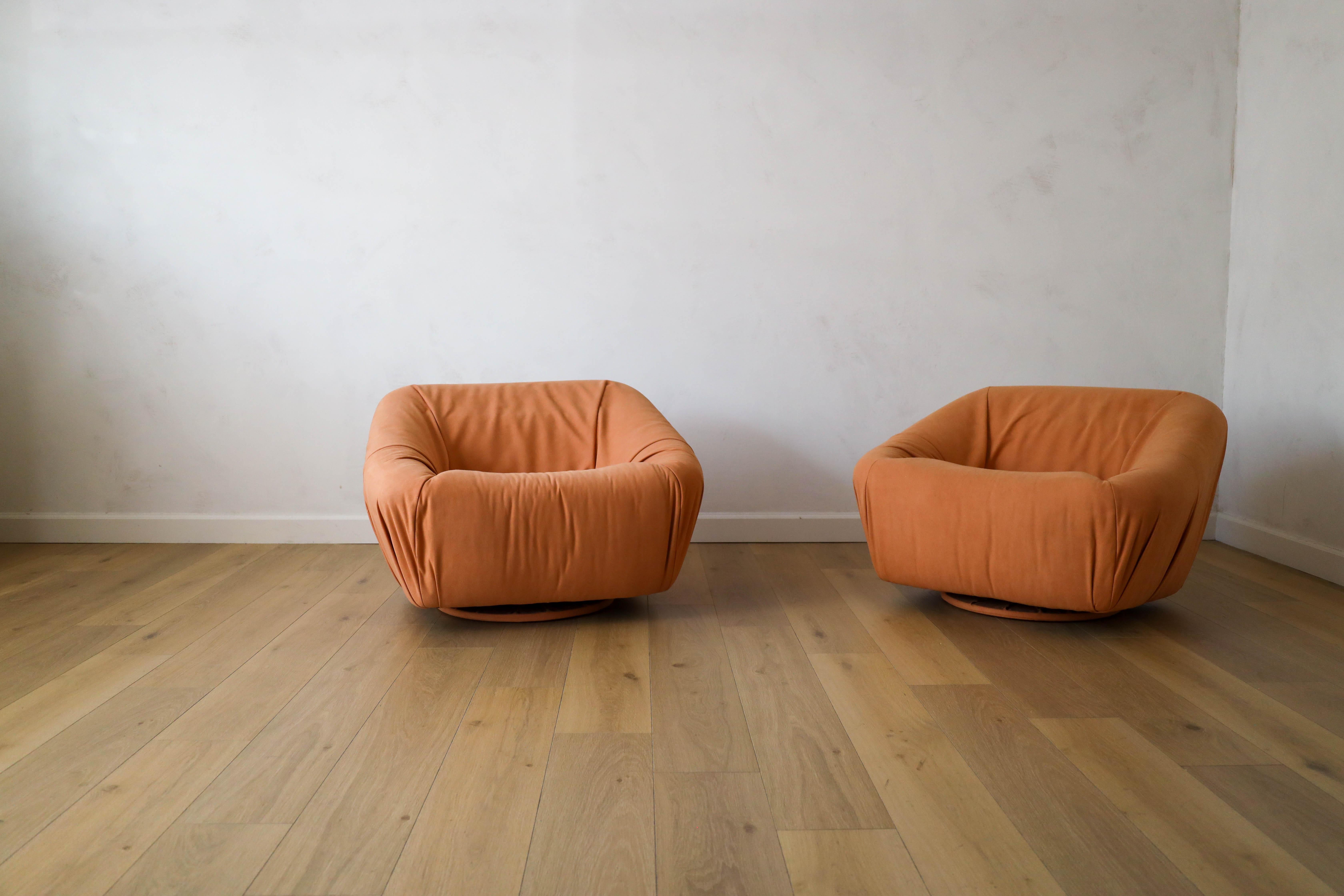 Ensemble de rares chaises pivotantes européennes datant des années 1950, retapissées dans un daim souple et luxueux dans les tons de curcuma par Kirky Design via The Romo Group. La paire offre à la fois style et confort tout en ajoutant une belle