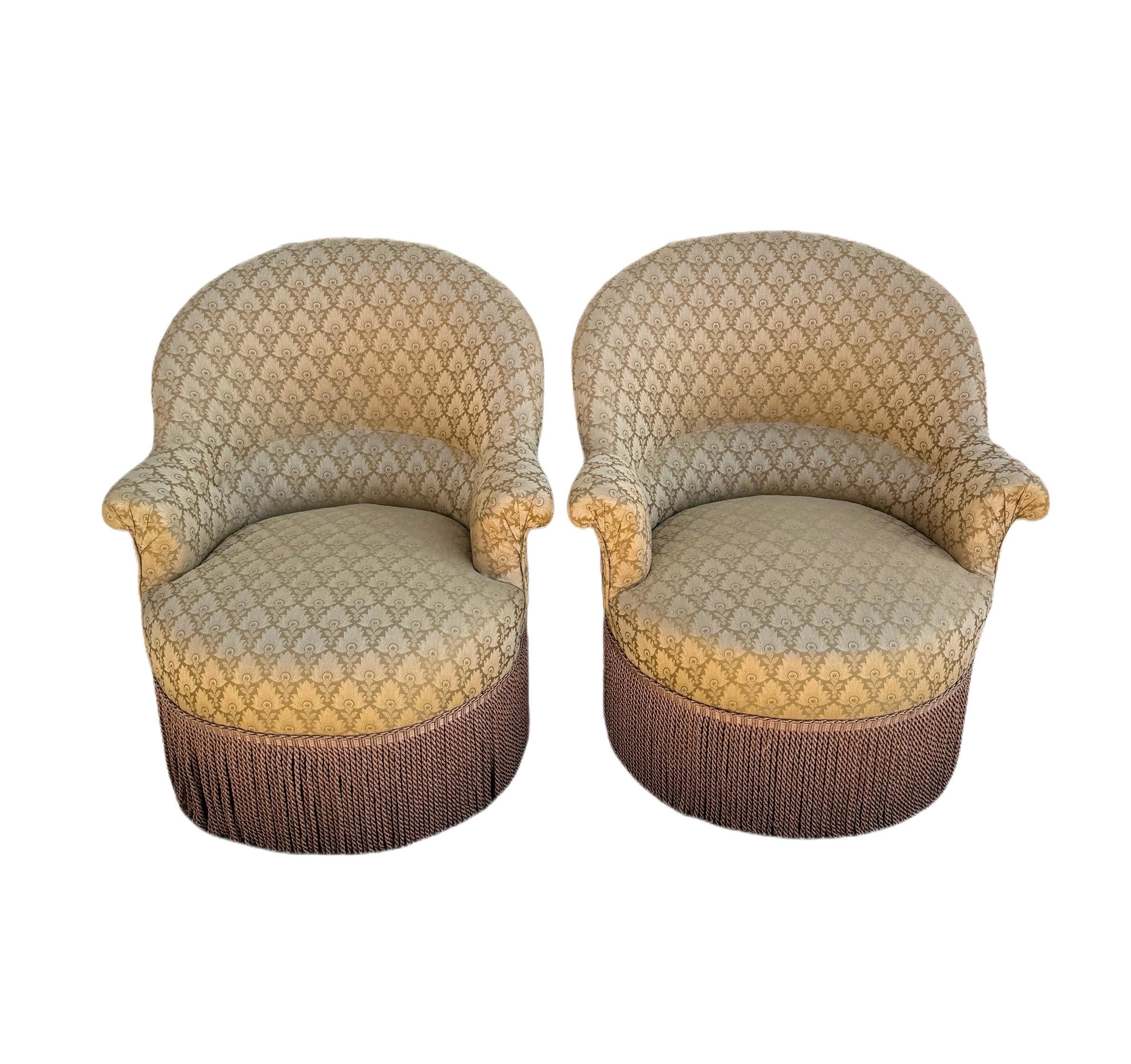 stunning pair of vintage Art Deco style chairs, beautifully upholstered in a luxurious gold plume silk damask fabric. These chairs boast an elegant silhouette with a sweeping curved backrest and a plush, rounded seat that invites one to sit and