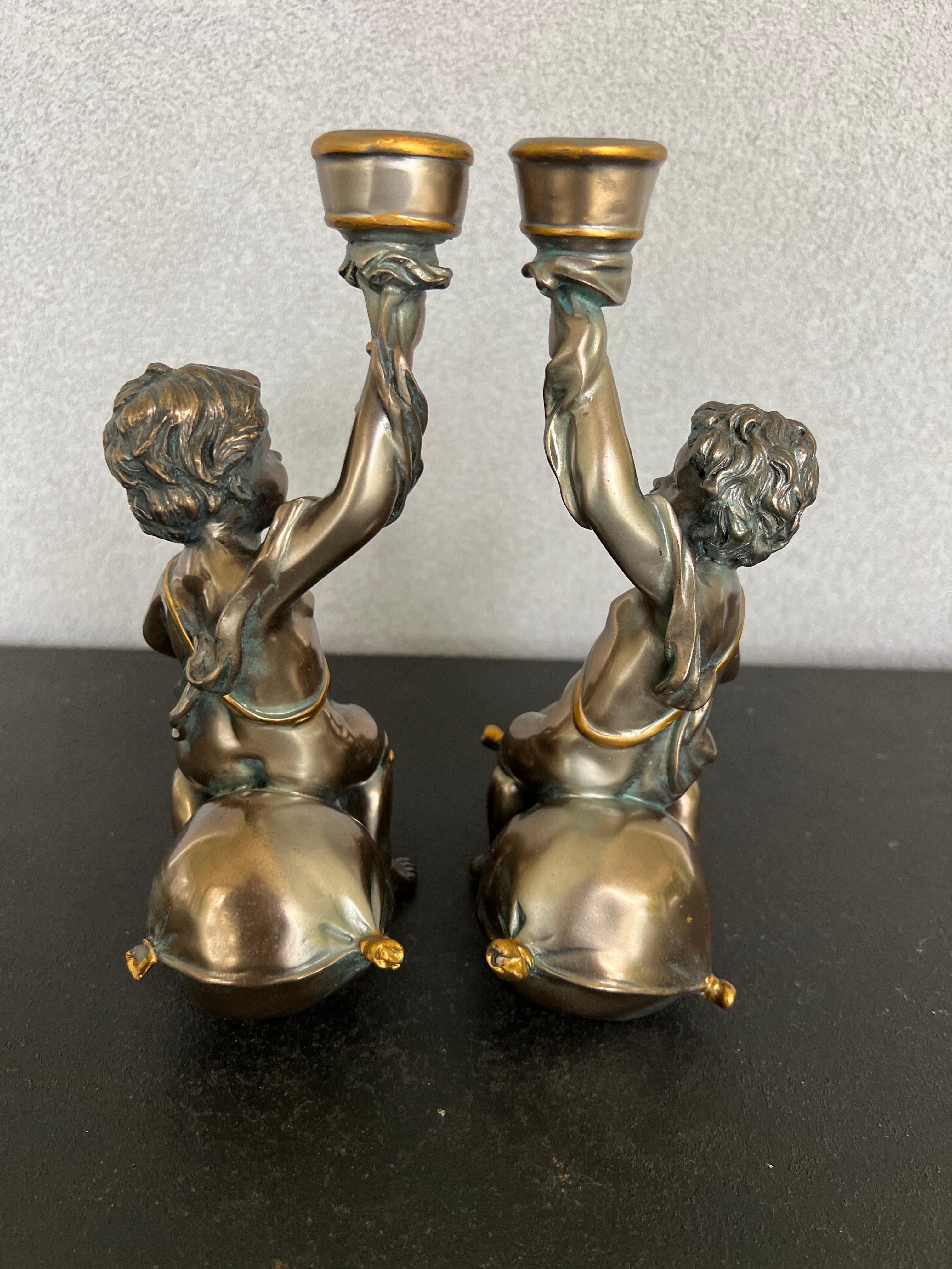 Gorgeous pair of Bacchus candlesticks in an antique bronze color, I believe they are made of resin. Beautiful details 
Bacchus was the Roman god of agriculture, wine and fertility, equivalent to the Greek god Dionysus.
Great pair to adorn a