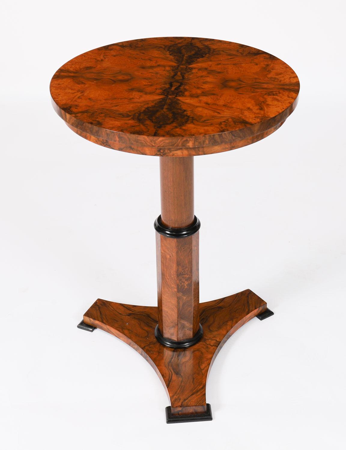 Si tratta di un'elegante coppia di tavolini vintage in radica di noce con bordi ebanizzati in classico stile Biedermeier, risalenti alla metà del XX secolo. 

I tavoli presentano un piano circolare su un piedistallo ottagonale sollevato da una base