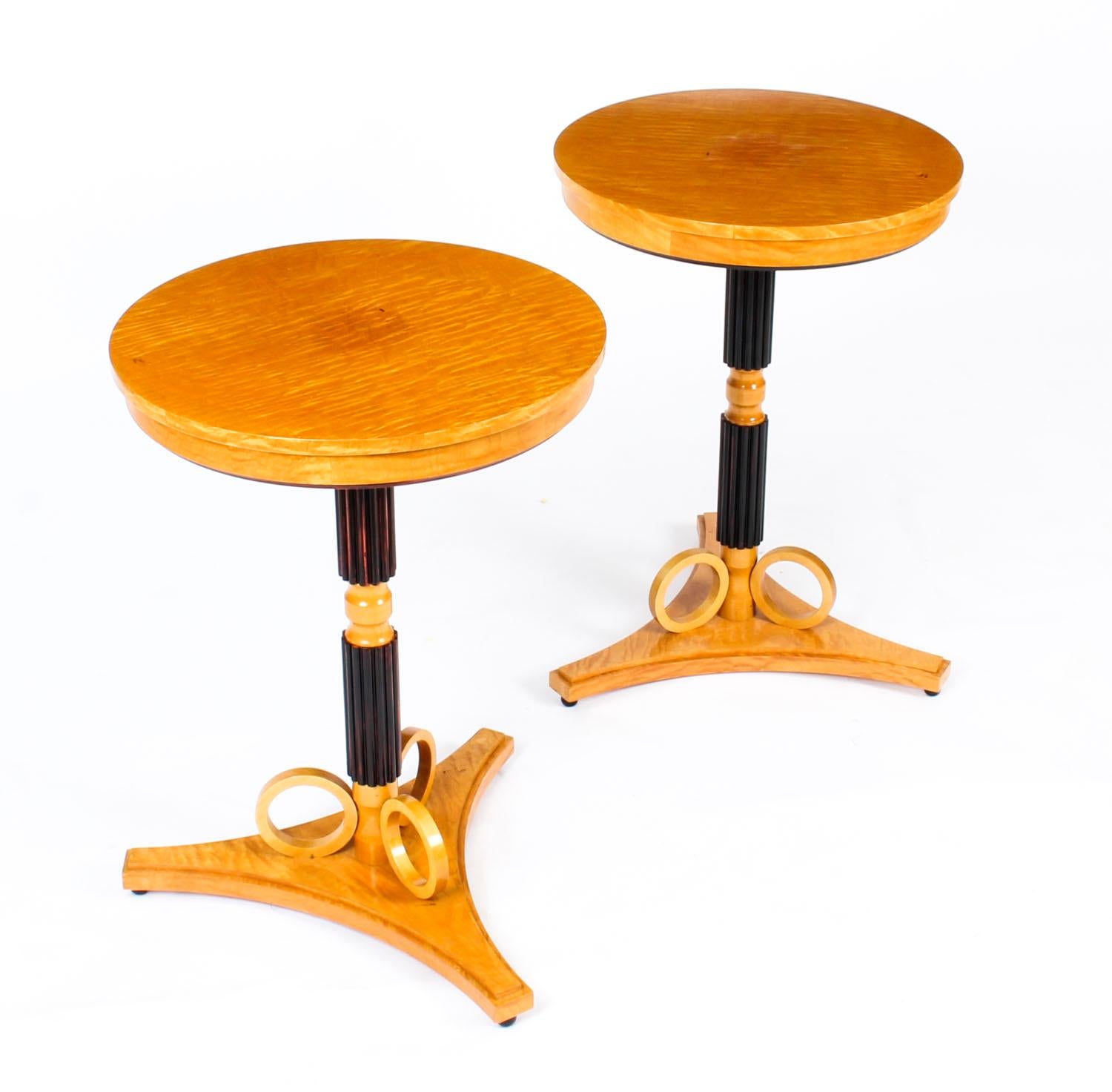 This is a stylish vintage pair of Swedish Biedermeier Karelian birch and ebonized side tables, mid-20th century in date.

The tables feature round tops on ebonized fluted column pedestals standing on shaped tripod platform bases raised on ebonized