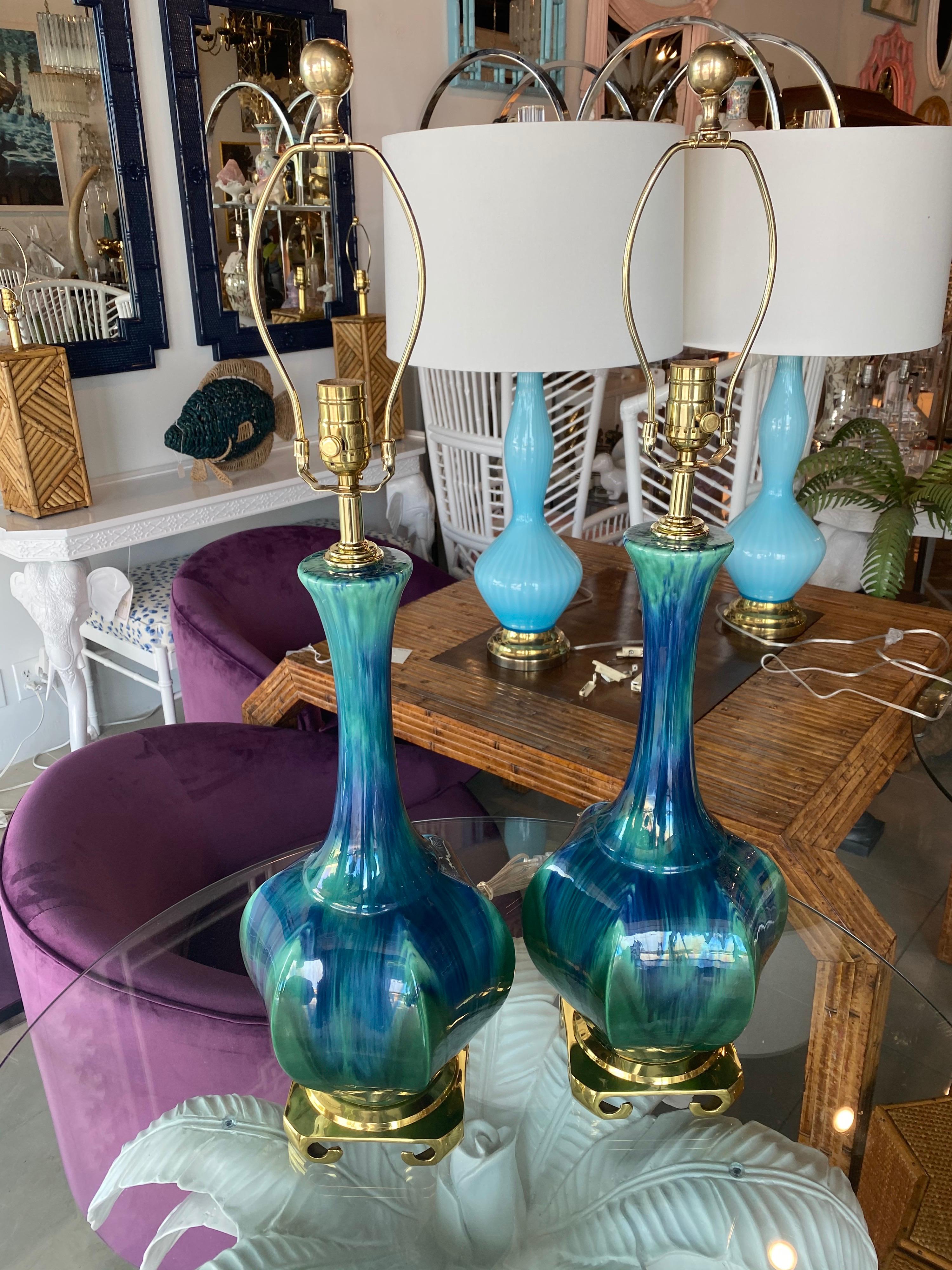 Lovely vintage pair of blue and green ceramic lamps with amazing color variations. These have been meticulously restored to perfection. These have been newly wired, all new brass hardware and Greek key brass bases and solid brass finials.