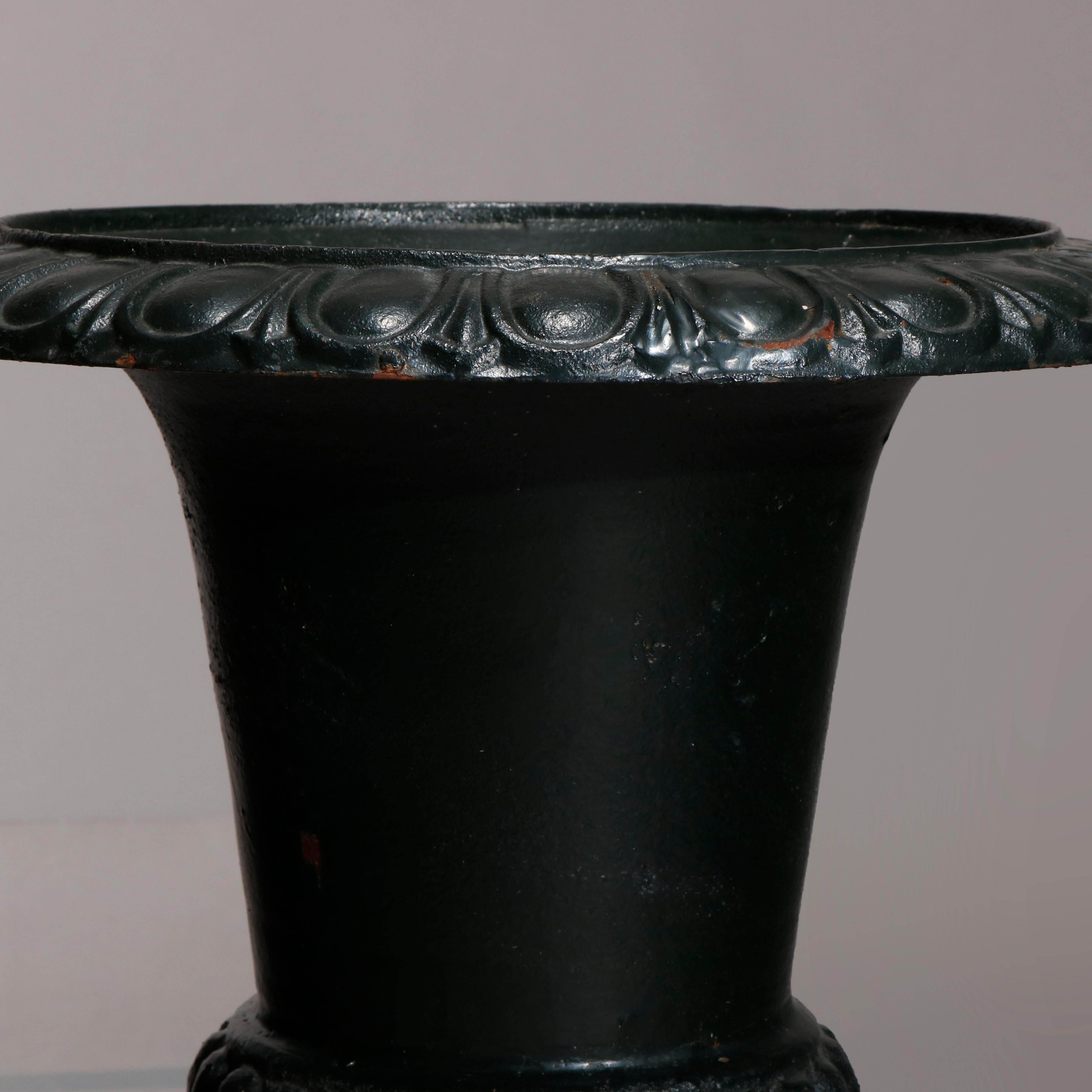 A vintage pair of Classical garden planters offer urn form with egg and dart rim and mellon base, raised on plinth with square base, 20th century.

Measures- 24.5