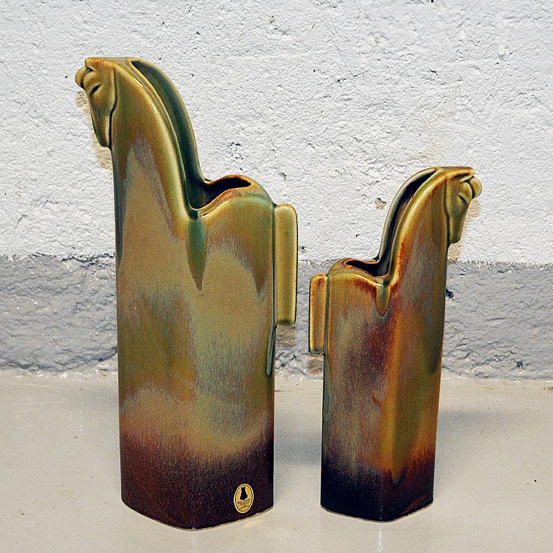 A beautiful and elegant pair of ceramic horses in glazed green brown colors by Rosa Ljung in Torekov, Sweden 1980s. These special design horses in two sizes are from the series Pampas Wild Horses and are perfect on the fireplace or shelf, window
