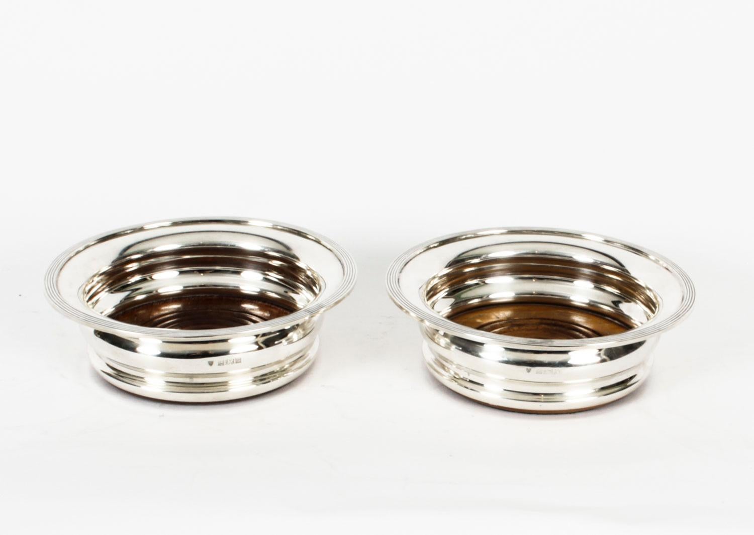 A superb pair of Elizabeth II sterling silver coasters, bearing the makers mark of J B Chatterley & Sons Ltd, and hallmarked for Birmingham, 1972.

Of circular waisted form with reeded rim and beech ring turned polished bases.


Condition:
In