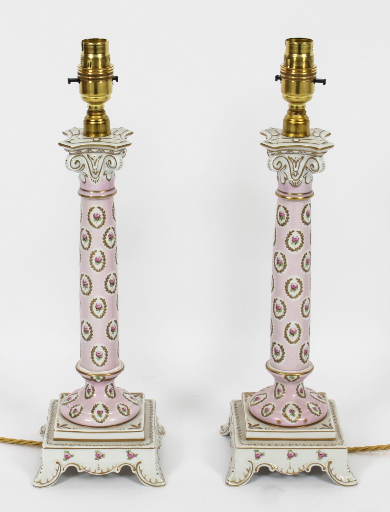 This is a beautiful vintage pair of Dresden porcelain electric table lamps, of candlestick form, the columns decorated with roses within gilt wreath on a pink ground, with leaf pattern feet and dating from the mid 20th century.

They are a