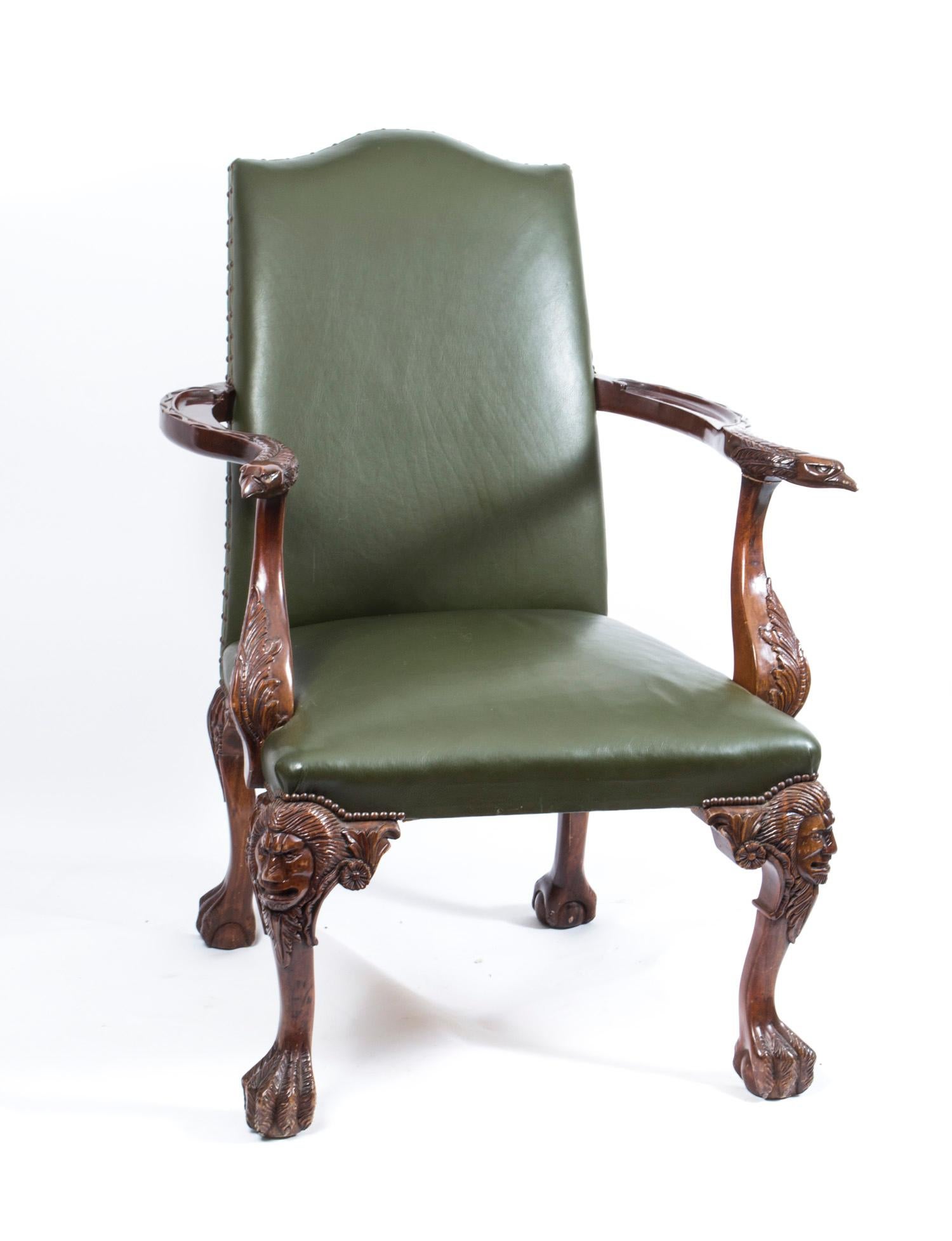 This is a superb pair of large leather library chairs dating from the mid-20th century.

These chairs have been masterfully crafted in beautiful solid mahogany and feature hand carved birds of prey decoration. 

The outswept arms terminate in carved