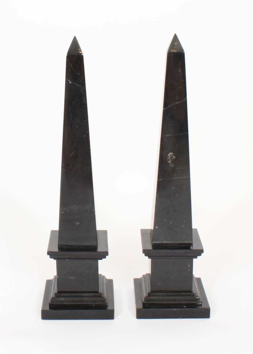 A stunning Vintage pair of large Empire Revival obelisks, dating from the late 20th Century.

They are made of a dark black'nero antico' marble, the finish and attention to detail throughout are fantastic.

A truly stunning pair of display pieces.
