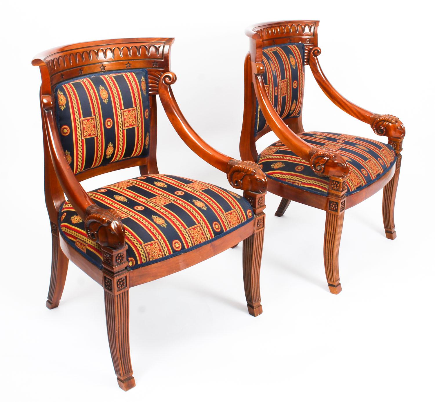 This is a beautiful pair of Empire Revival mahogany armchairs dating from the mid-20th century. 

The mahogany is a beautiful rich colour, the armchairs with upholstered back and seats with scrolling downward swept arms that terminate in carved