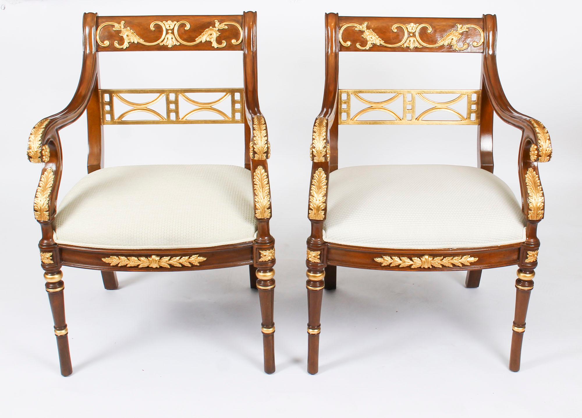 This is a beautiful vintage pair of Empire Revival mahogany and giltwood armchairs, late 20th century in date. 

The mahogany is beautiful in color and has been embellished with striking gilded high-lights in the form of acathus leaves and c