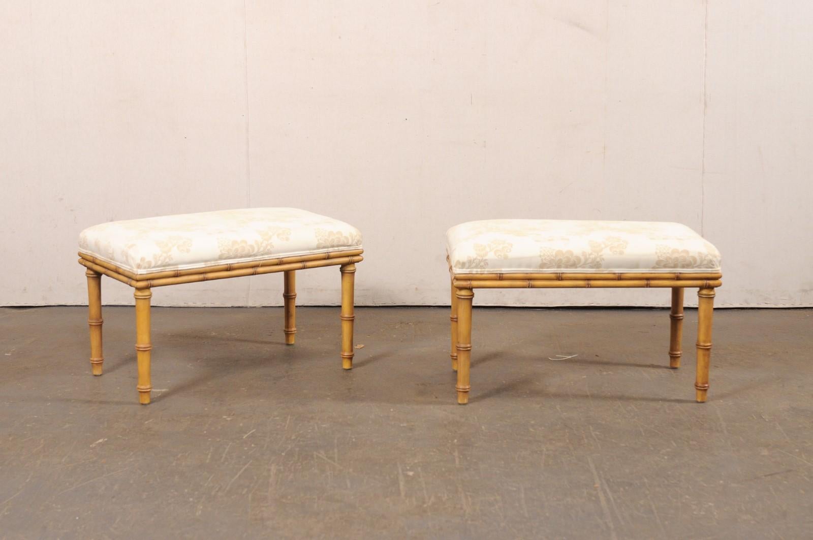 Una coppia vintage di panche americane in legno finto-bambù con sedute imbottite. Queste piccole e graziose panchine misurano poco più di 2,5 piedi di larghezza. Le cornici sono in legno e sono state intagliate per imitare il design del bambù. Il