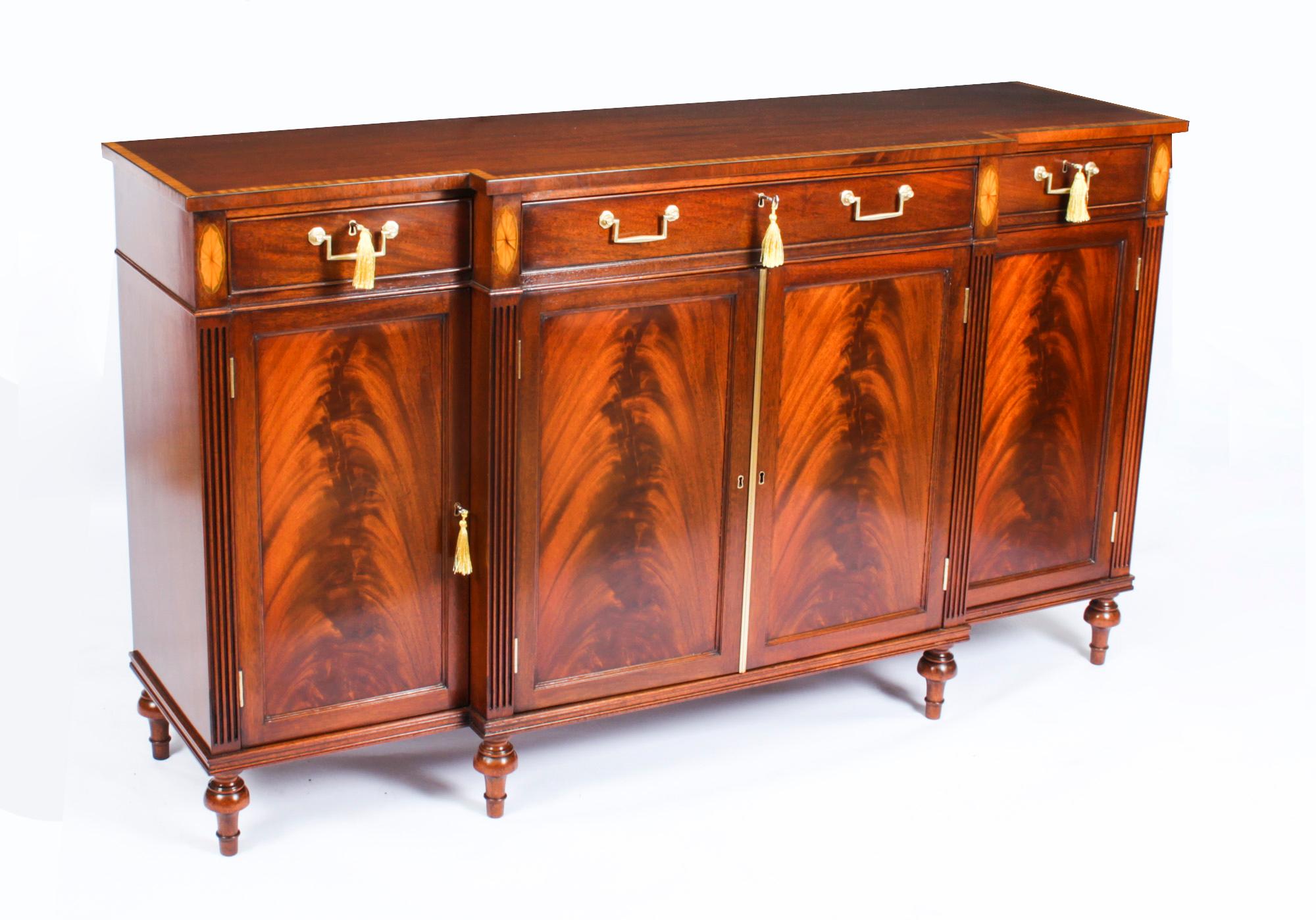 This is a fabulous pair of vintage Regency Revival breakfront sideboards by the master cabinet maker William Tillman, Circa 1980 in date.

They are made of stunning flame mahogany crossbanded in satinwood, fitted with drawers and cupboards and