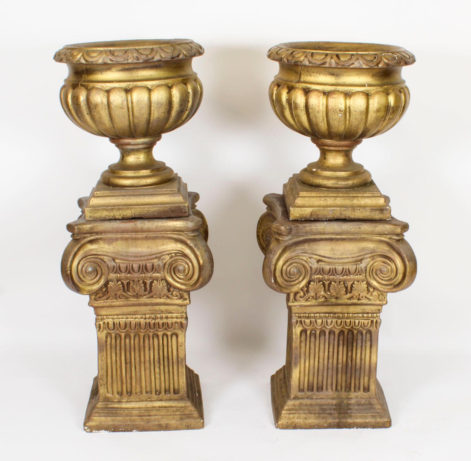 A decorative vintage pair of late 20th century Hollywood Regency classical garden urns / planters of fiberglass construction. Each having an urn top supported by Roman style column bases. 

Condition:
In good condition. As vintage items, the urns