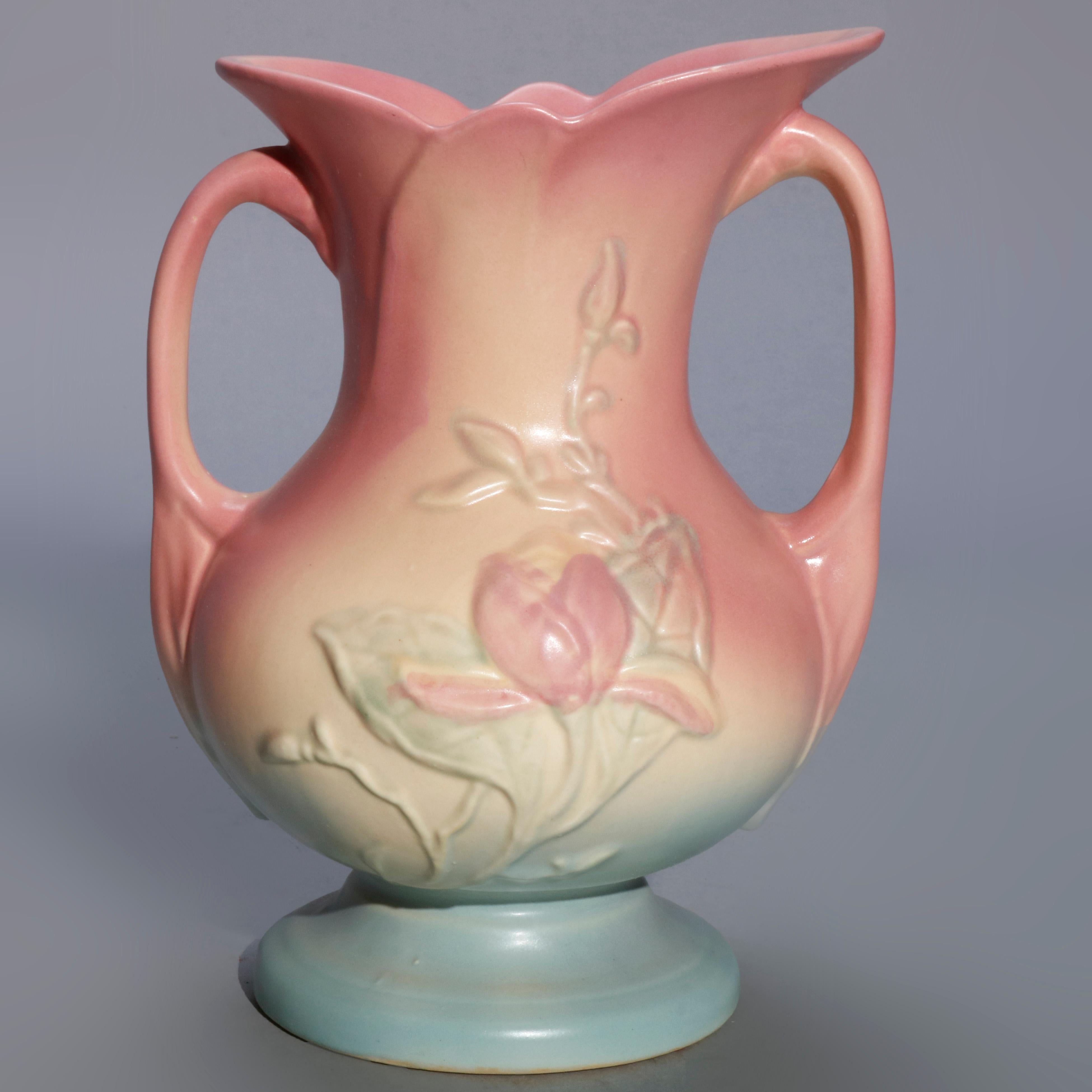 A pair of vintage Hull art pottery double handled bow knot vases offer tulip form mouth with floral decorated body having double scroll form handles, maker mark on base as photographed, circa 1940

Measures- 8.75