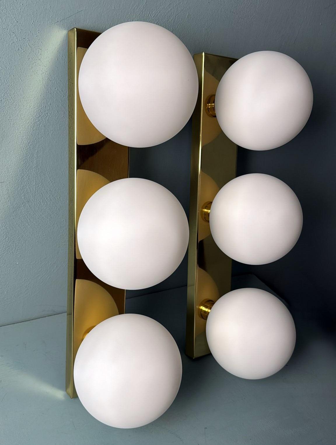 Moderne Paire d'appliques murales italiennes d'époque  Cadre en laiton et trois globes en verre opalin en vente