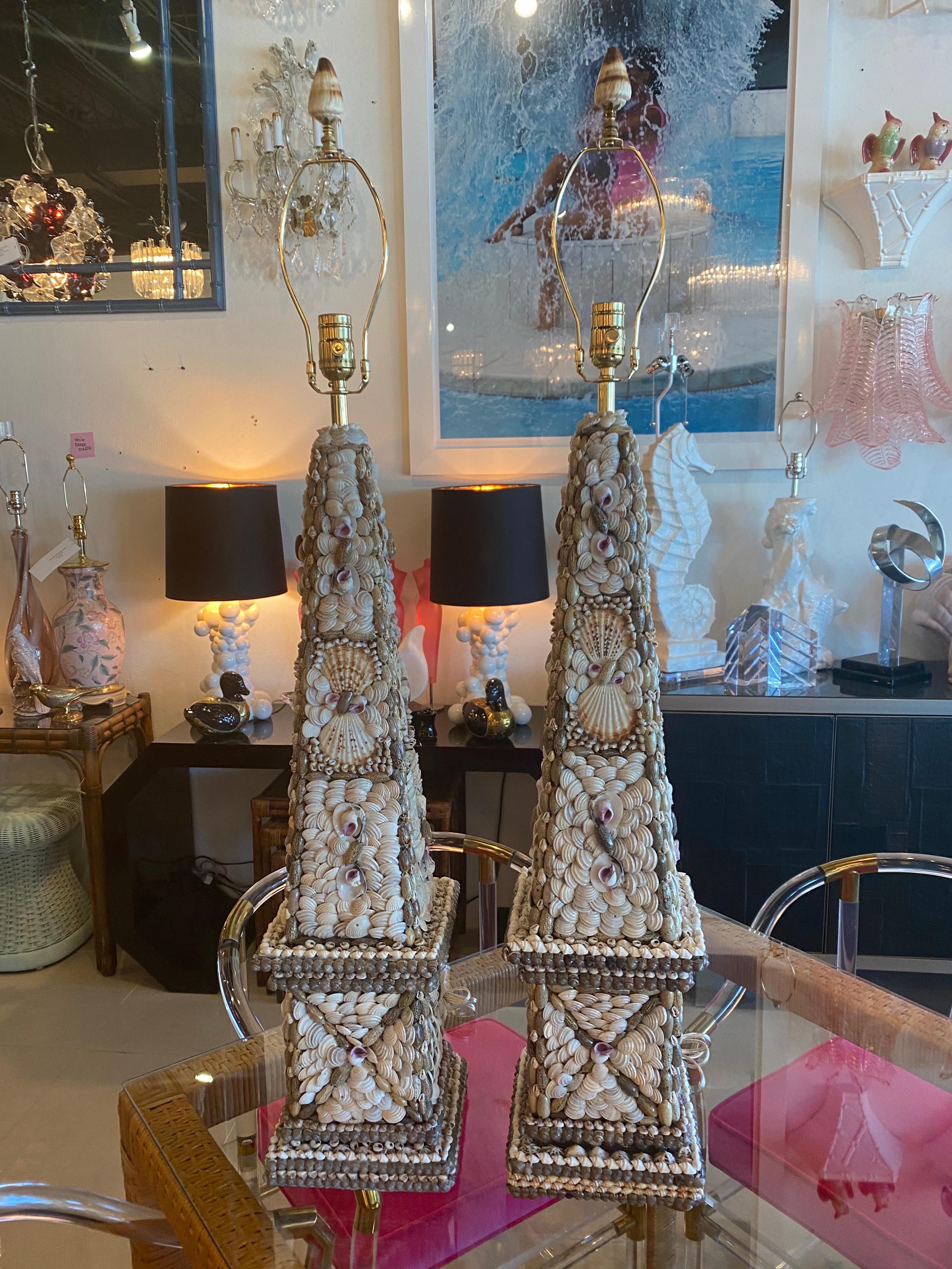 Lovely pair of vintage seashell shell obelisk table lamps. These have been newly wired with all new 3 way brass sockets and hardware. Comes with original matching shell finial. Measures 34.5 H to socket x 43.5 H to top of shell finial x 8 W x 8 D.