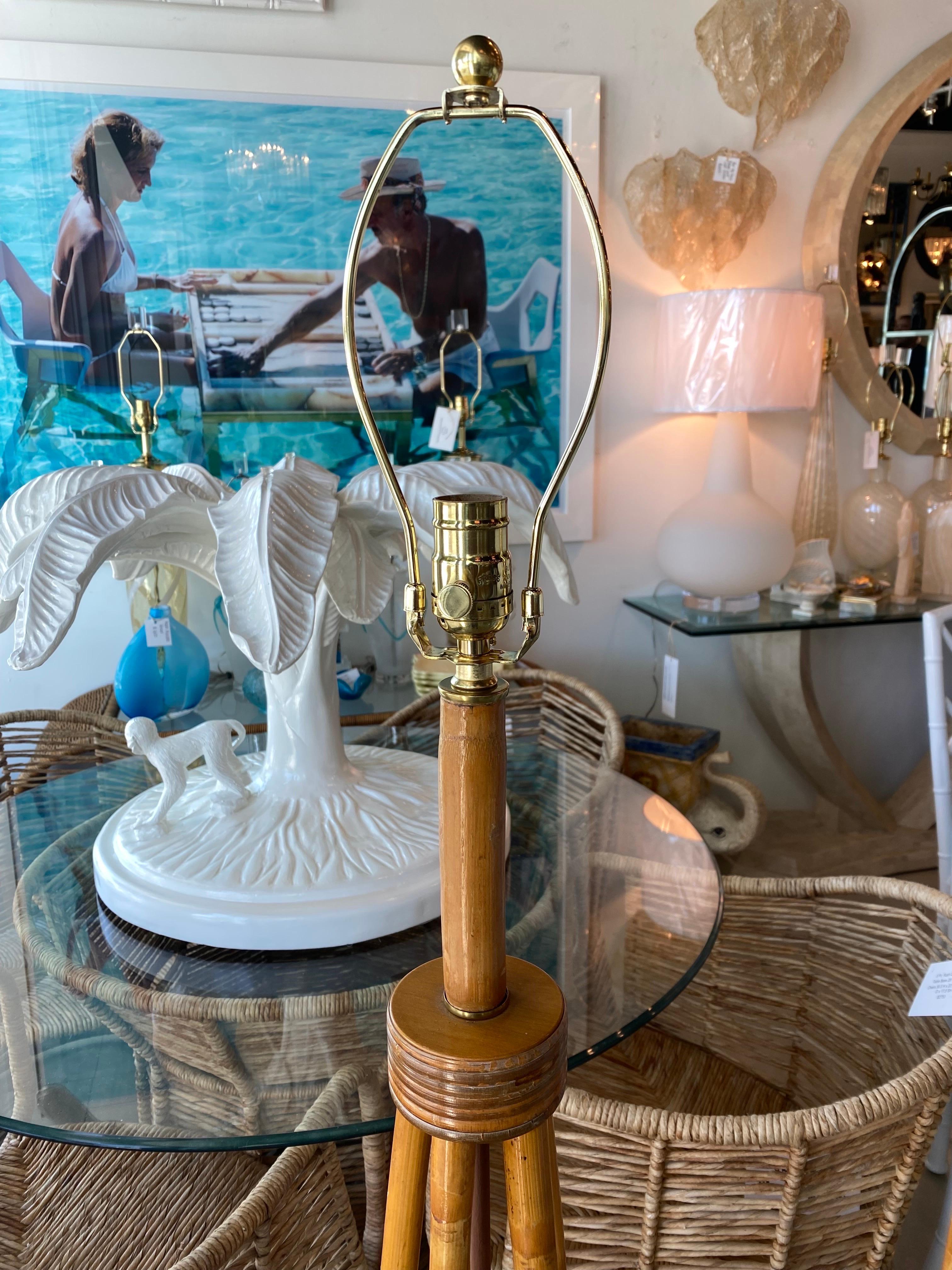 Lovely vintage pair of 1950s rattan floor lamps. These have been professional wired with 3 way sockets in brass. Original vintage natural finish. Dimensions: 11 D x 49 H (to socket) x 56 H (to top of finial).