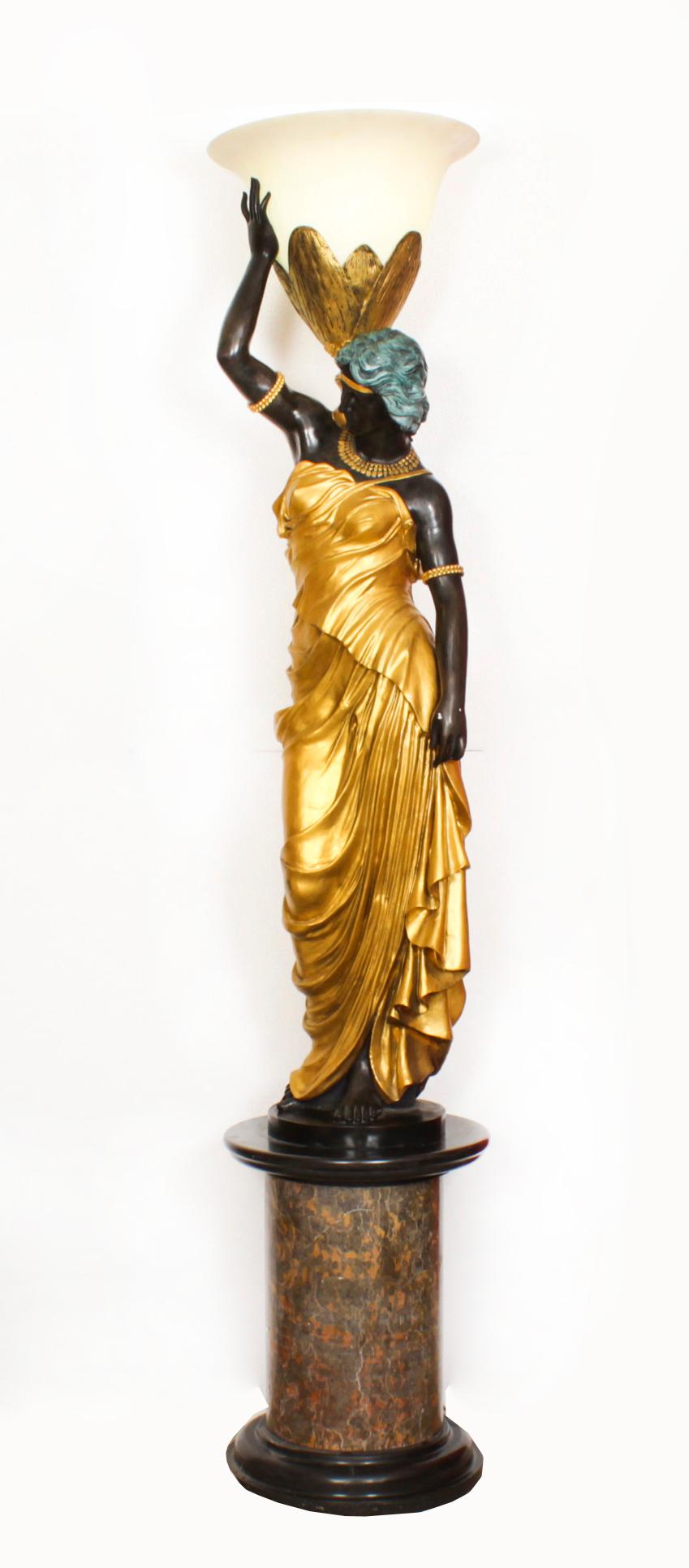 After Milo, Miguel Fernando Lopez, Portuguese, contemporary, a magnificent monumental pair of gilded life size lady statue bronze lamps set on circular two colour solid marble bases, Circa 1980 in date.

The two ladies are adorned in long and