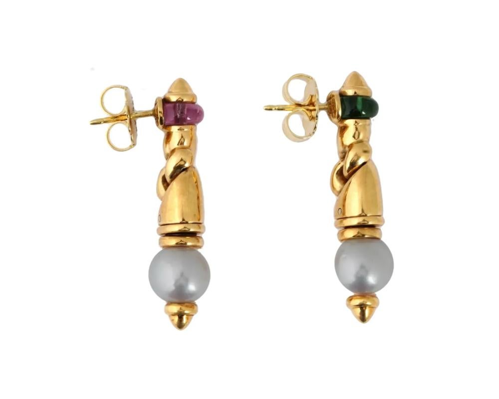 A pair of vintage Bulgari Passo Doppio 14K gold dangle stud earrings. Each earring features polished gemstones, perfectly complemented by round pearls, creating a harmonious blend of colors and textures. The intricate design of the earrings