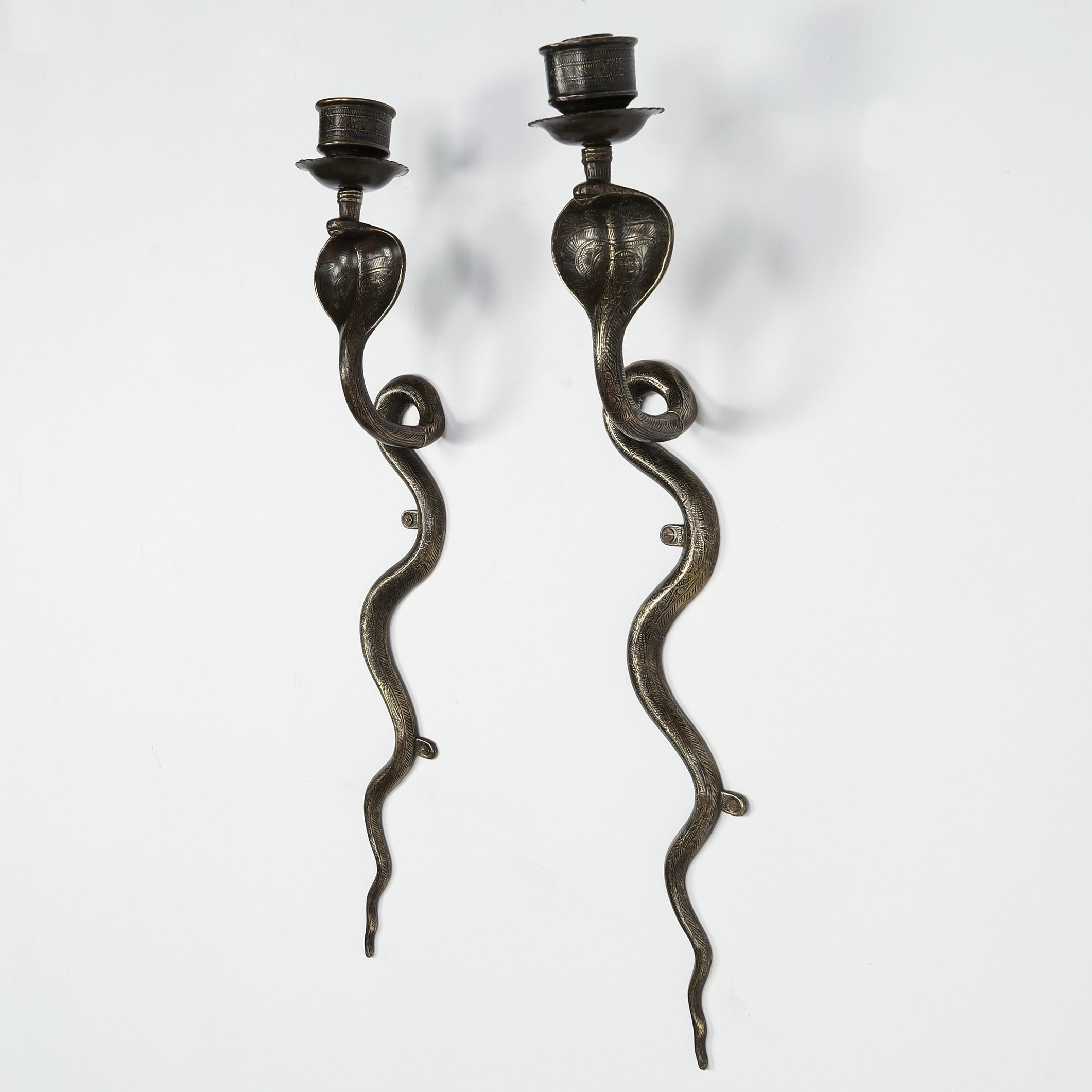 Coppia di appliques a forma di cobra a candela di origine anglo-indiana della metà del secolo, realizzate in ottone con disegni floreali e geometrici incisi.