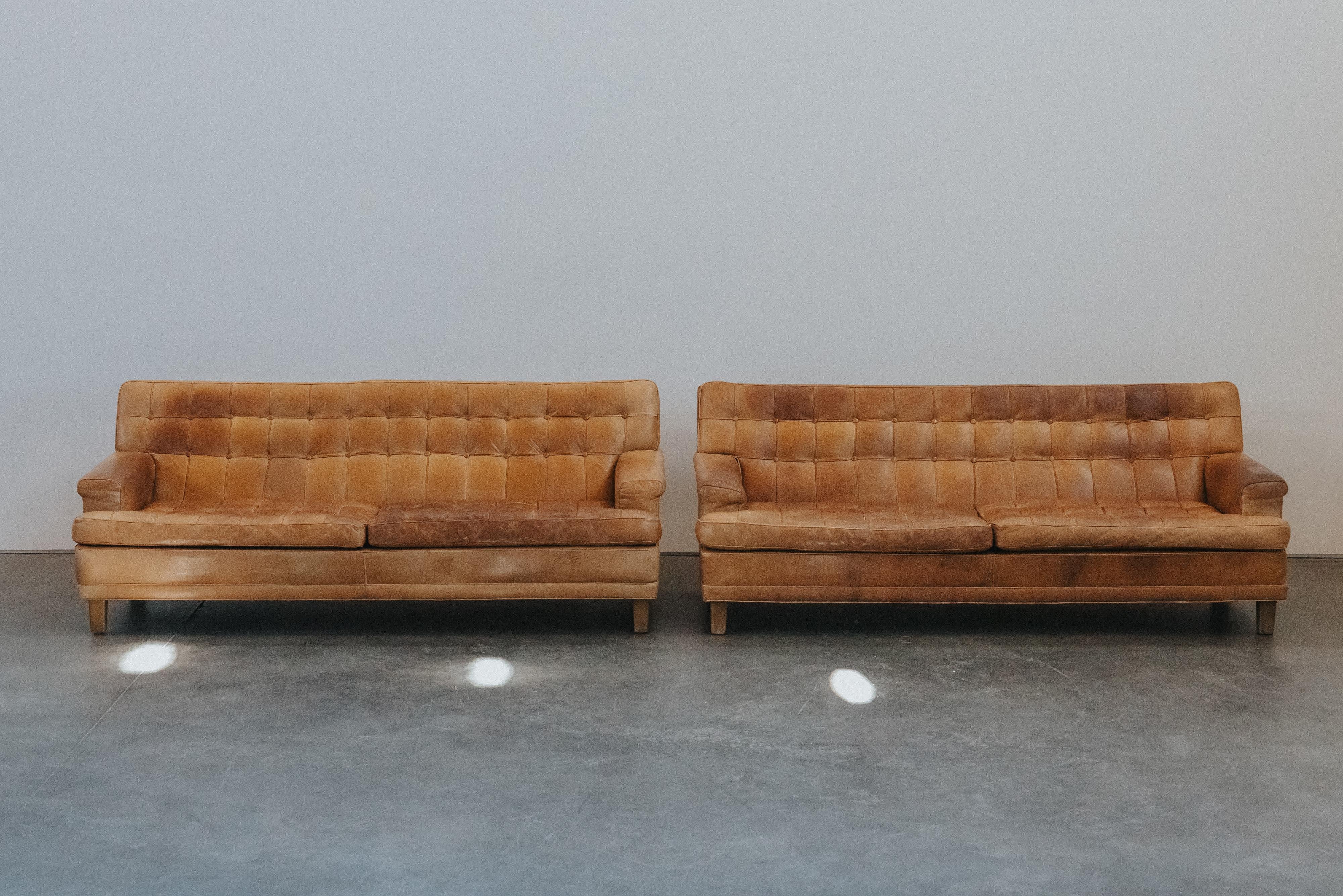 Pareja vintage de sofás Merkur de cuero de Arne Norell, Suecia, circa 1970.  Tapicería original de cuero coñac con una pátina y un uso fantásticos.
