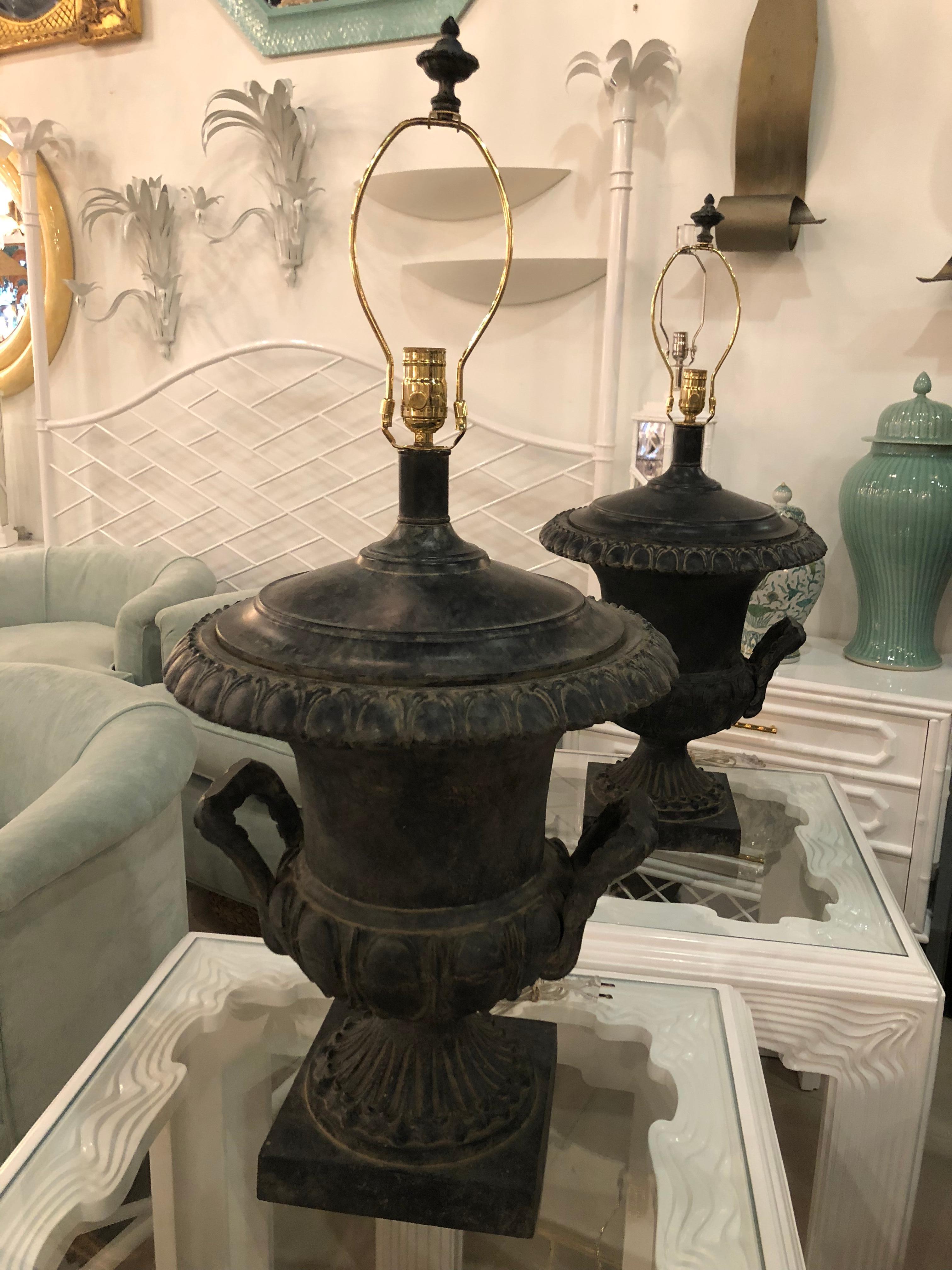 Lovely pair of vintage French black oversized urn table lamps. These have been newly wired and have all new brass hardware. Includes original matching finials. 
35 tall to finial
26 tall to socket.
