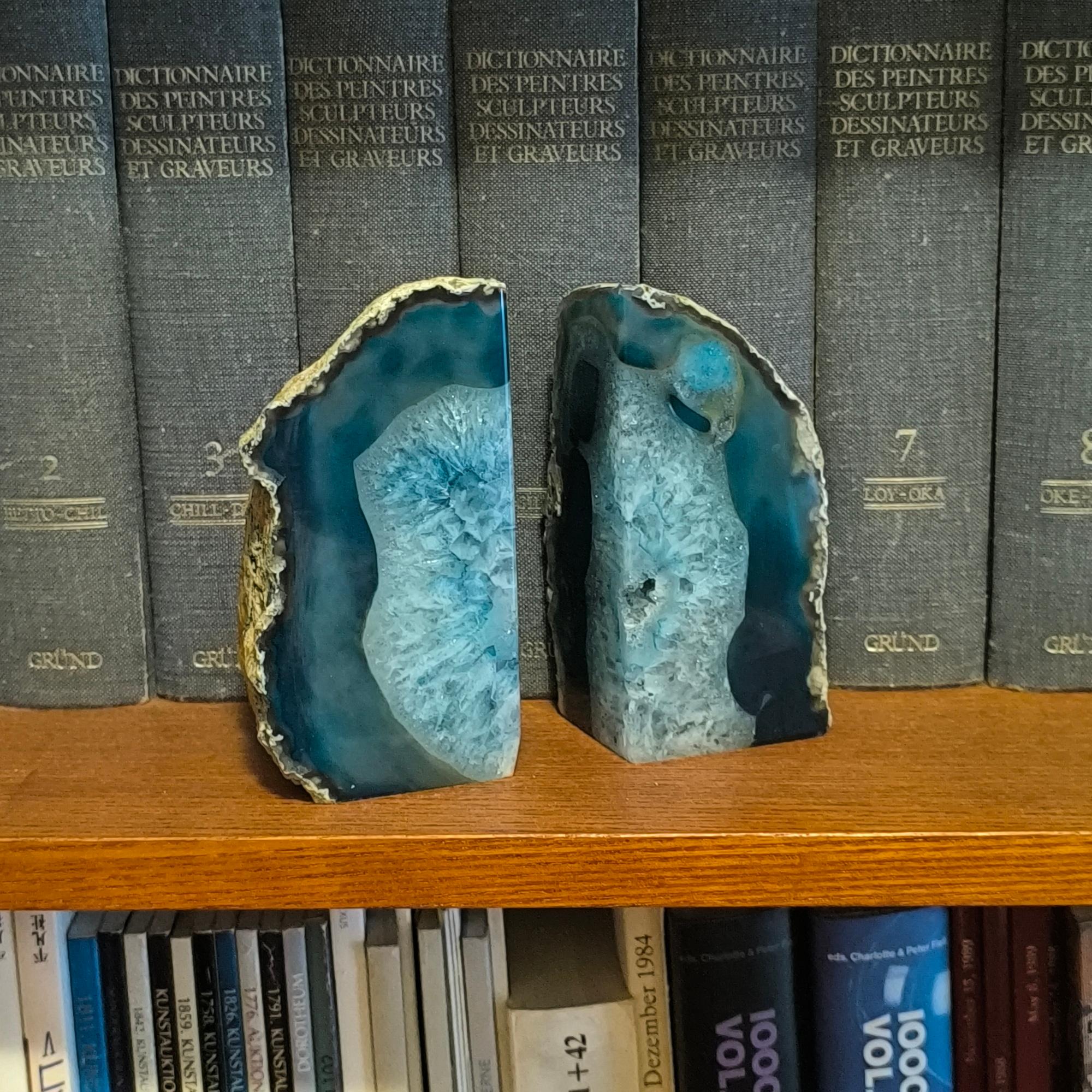 Add a touch of vintage charm to your space with these 1970s blue agate bookends. Blue agate, a type of chalcedony and member of the quartz family, forms in volcanic rocks and boasts stunning color and texture. These bookends symbolize inner peace,