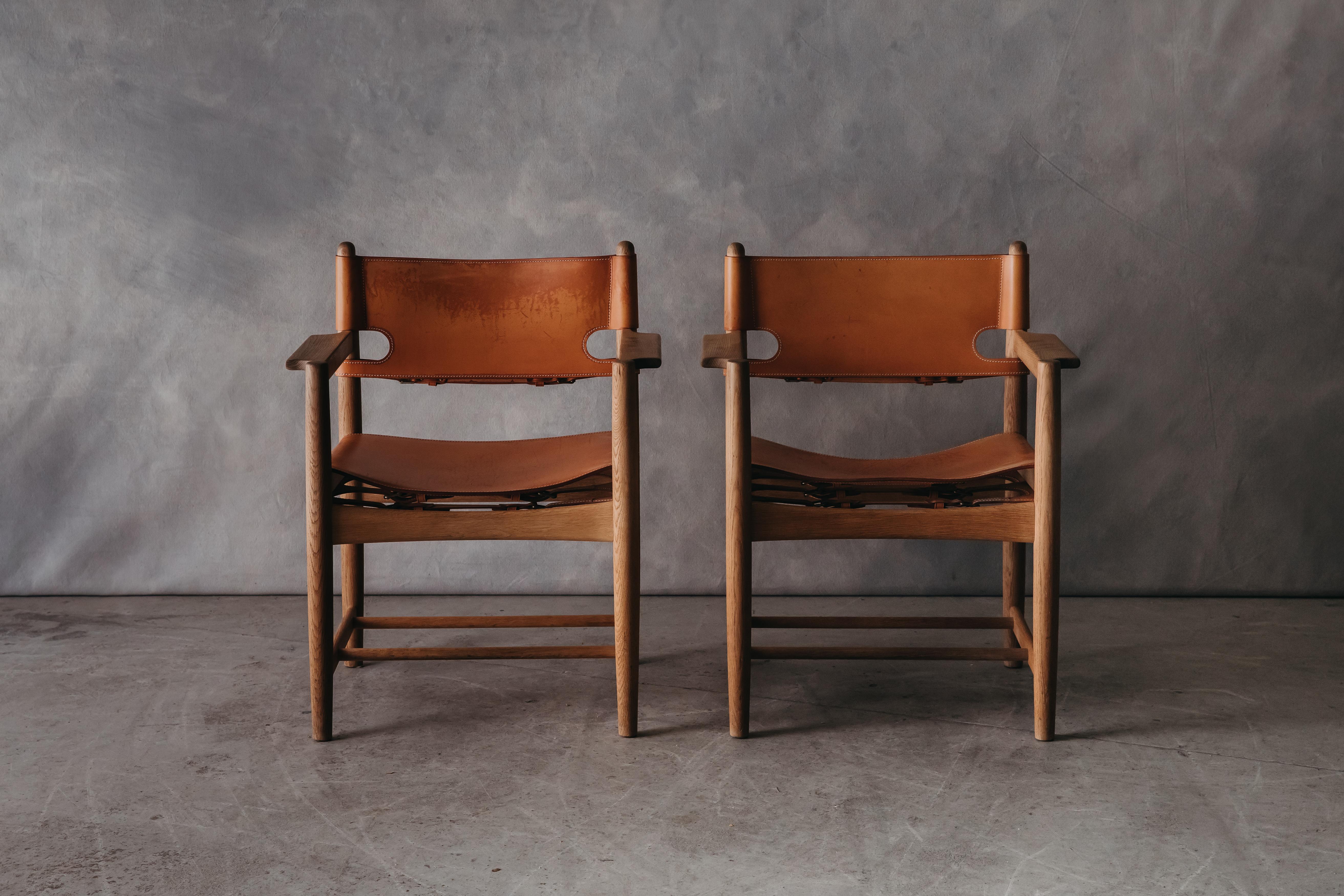 Vintage Pair Of Borge Mogensen Dining Chairs From Denmark, circa 1970. Solid oak construction with original cognac leather upholstery. Nice wear and patina.