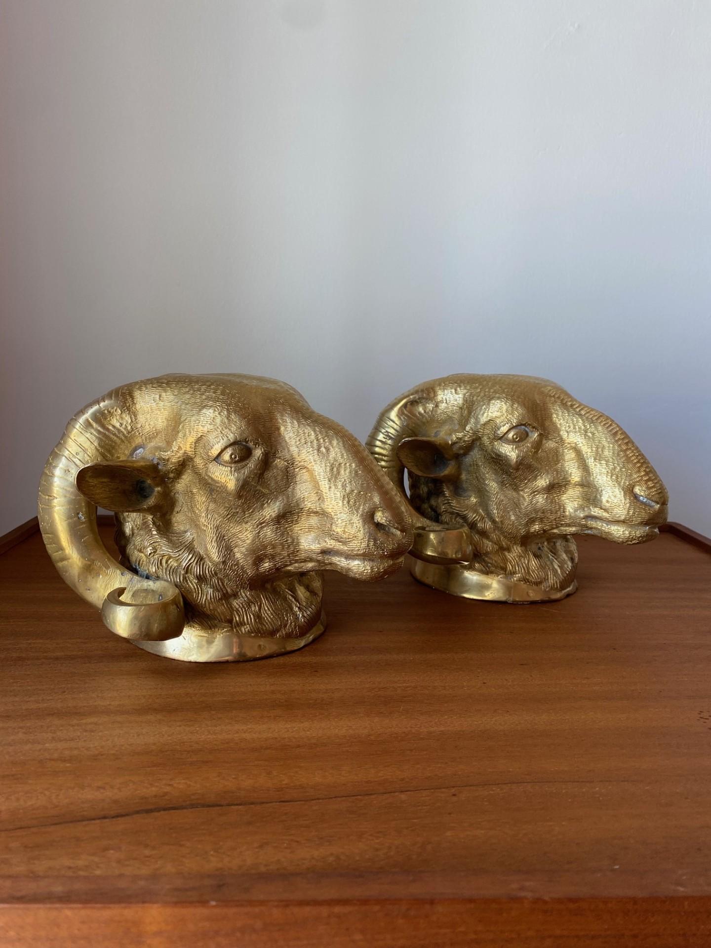 Impressive pair of Italian patinated brass big horn ram's head sculptures featuring long curled horns and dramatic neoclassical styling. These pieces stand out with Intricate details and beautiful craftsmanship. The artistry of movement develops in