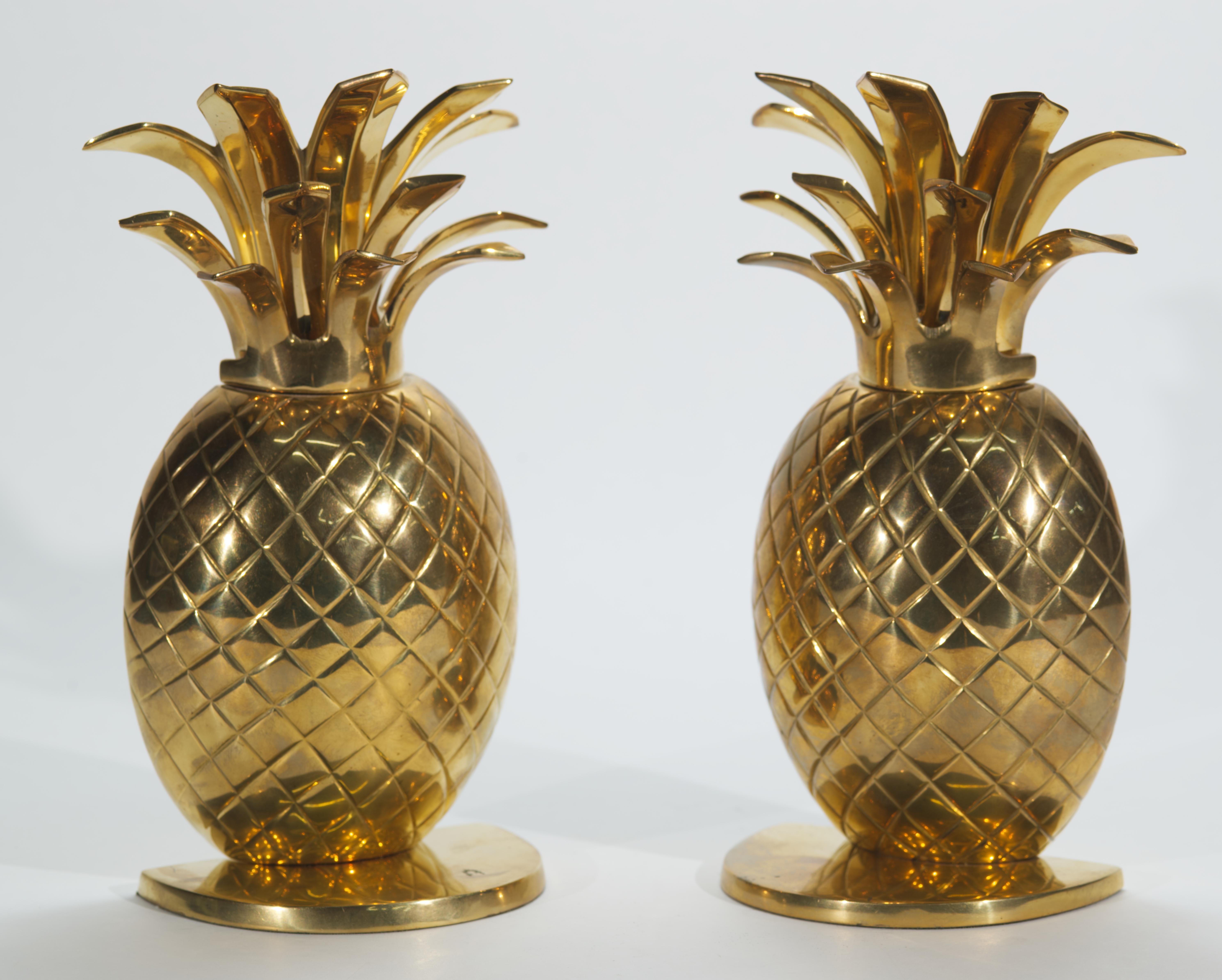 Vintage heavy solid brass pair of pineapple bookends feature textured, detailed bodies, mounted on rounded base, and sculptural three-tier tops. The pieces are heavy enough to be used as doorstops. As early as in the 18th century, the pineapple was