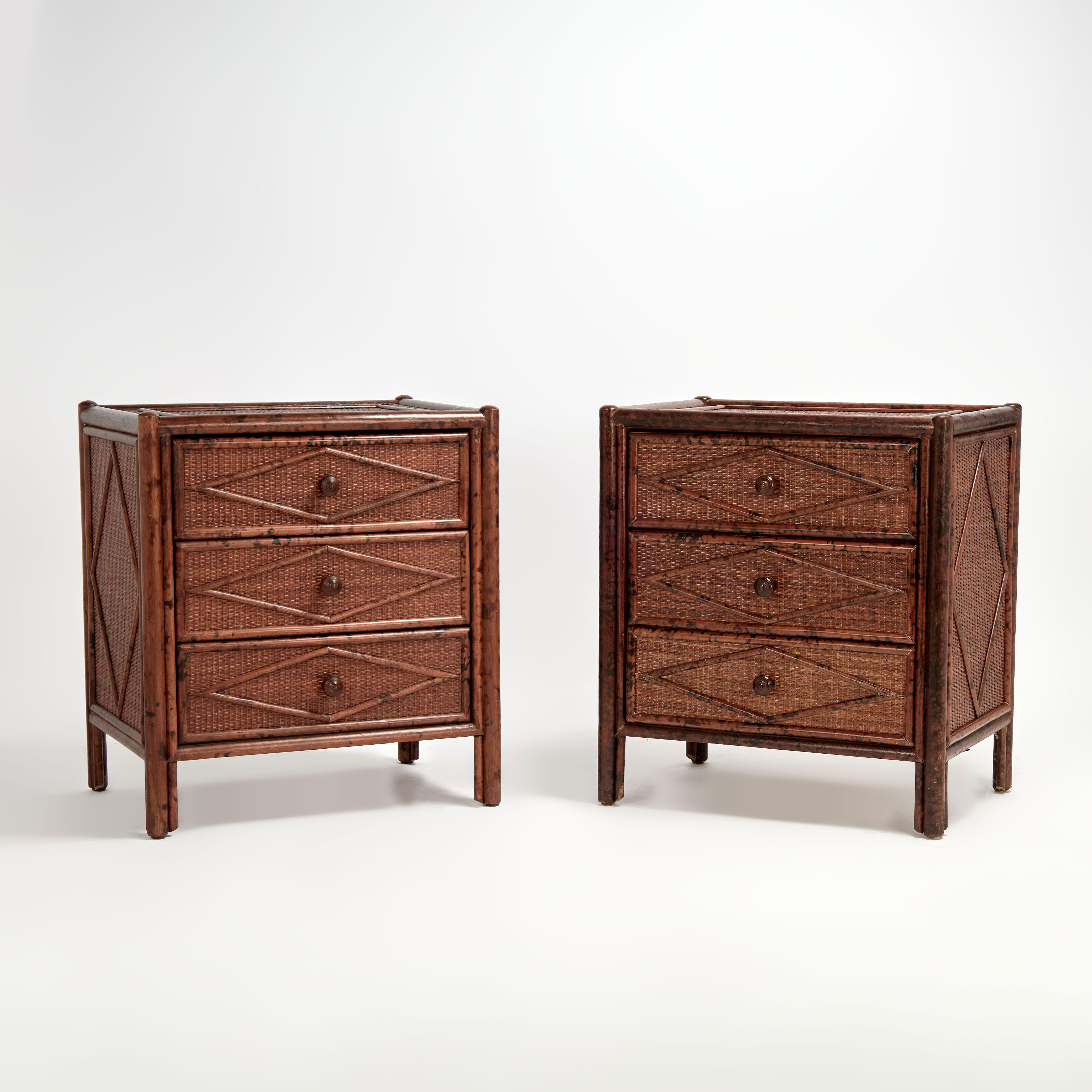 Paire de tables de nuit à trois tiroirs du milieu du siècle, fabriquées avec des cadres en faux bambou et des panneaux en gazon tout autour avec des motifs géométriques en faux bambou appliqués sur le dessus, les côtés et l'avant. Signé par