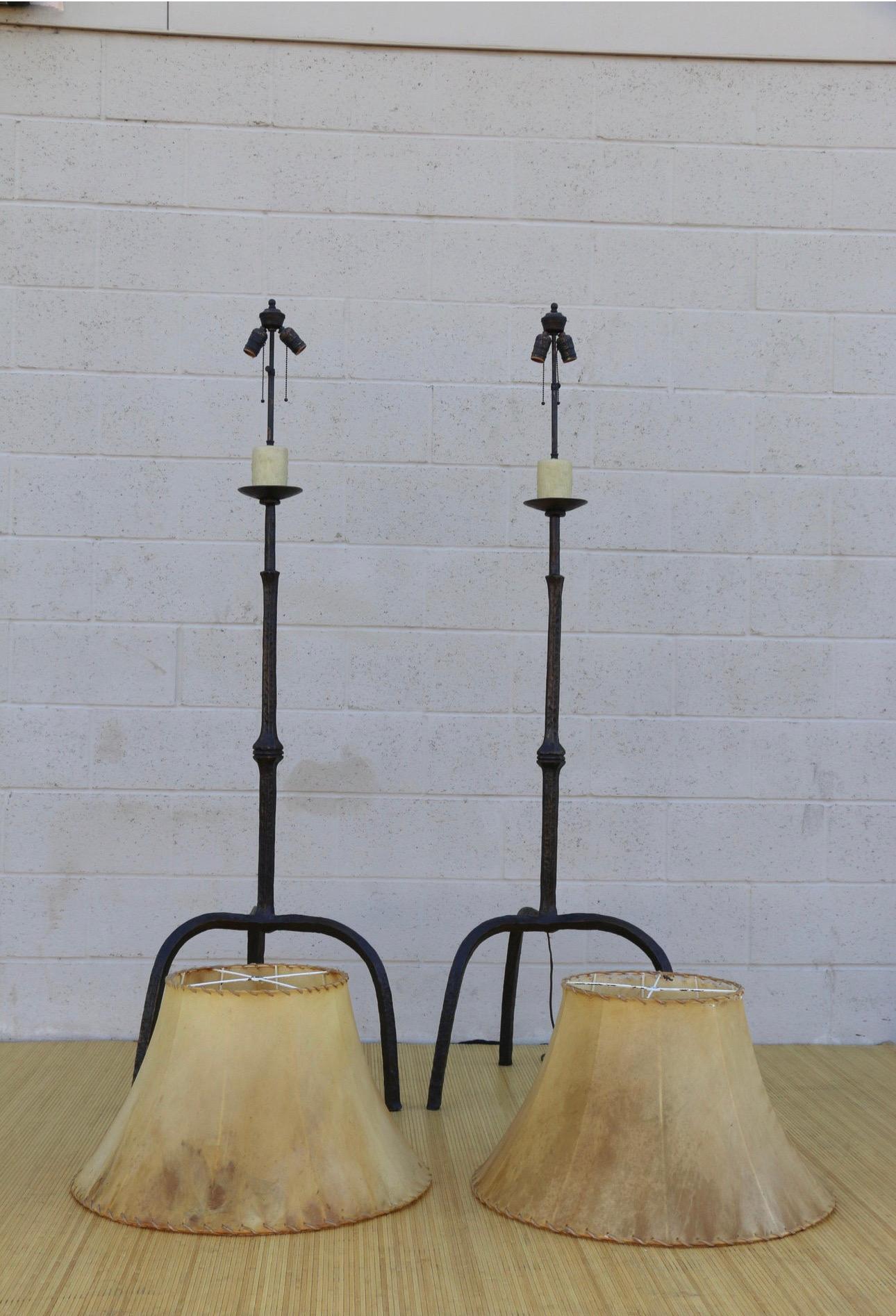 Spectacular pair of unique tripod base floor lamp made of bronze and goatskin lampshades. They are in vintage condition. Its lampshades has some imperfections, ( check it out in the pictures). The lamps are in excellent condition. They are really