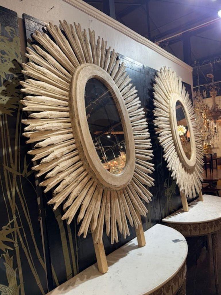 Questa coppia di specchi vintage di grandi dimensioni con cornice bianca intagliata a raggiera emana uno stile italiano grazie alla finitura della cornice bianca e alla superficie a specchio.  Perfetti per aggiungere un tocco di charme vintage a