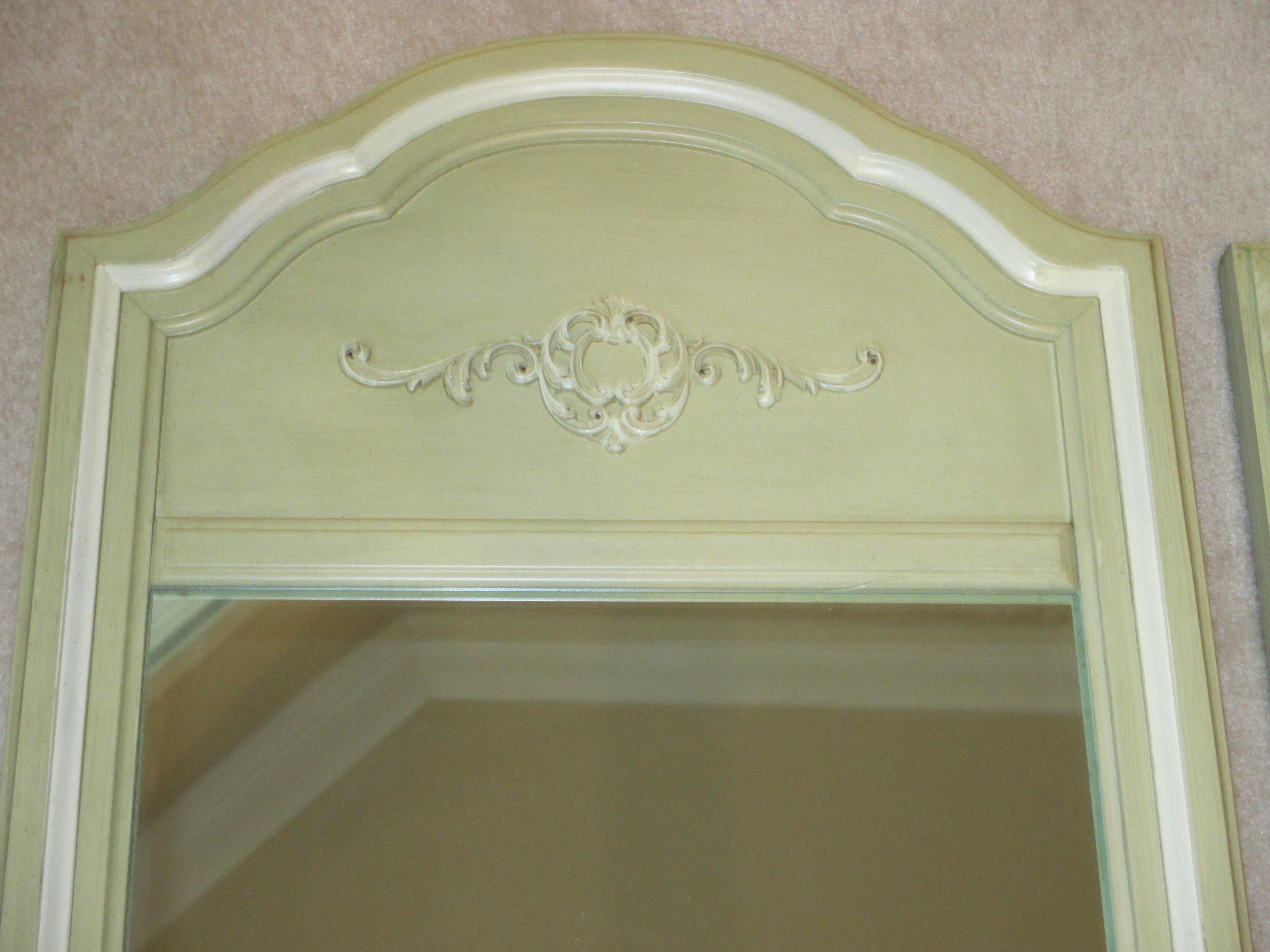Beautiful pair of celery green painted wooden mirrors with decorative accent. Hanging hardware is attached.