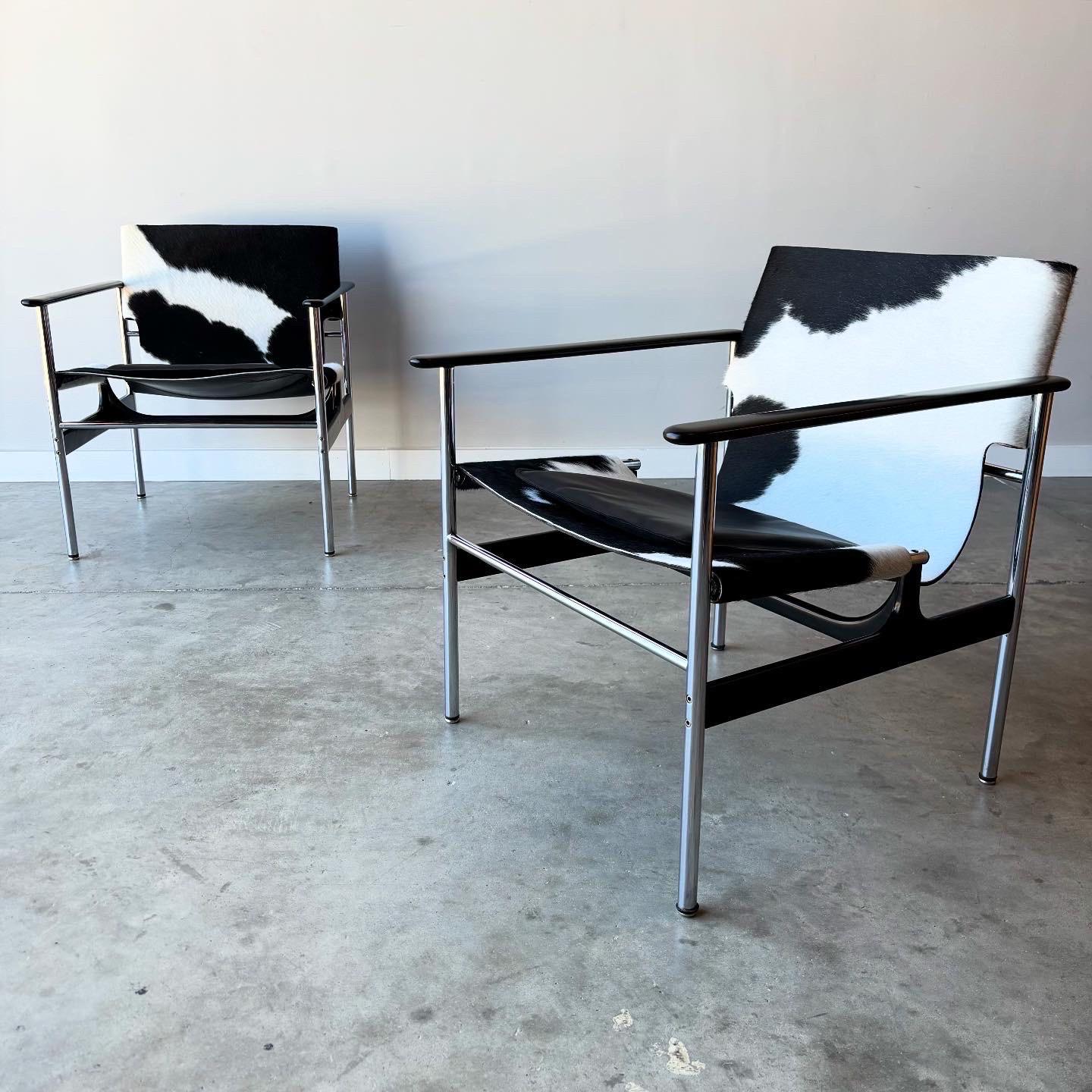 Un llamativo par de sillas de honda vintage de Charles Pollock.  Tienen una nueva tapicería de piel de vaca sobre el arnés de cuero original, una actualización única y artística del diseño original.  Con el asiento bajo y los brazos encapsulados,