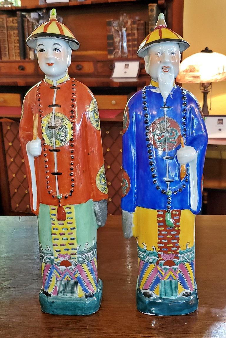 Presenting a lovely vintage pair of Chinese ceramic noblemen.

20th century, circa 1960-1980.

One nobleman or Courteneer has a blue tunic with beard, hat and beautifully hand decorated front and back.

The other one is dressed in an orange tunic,