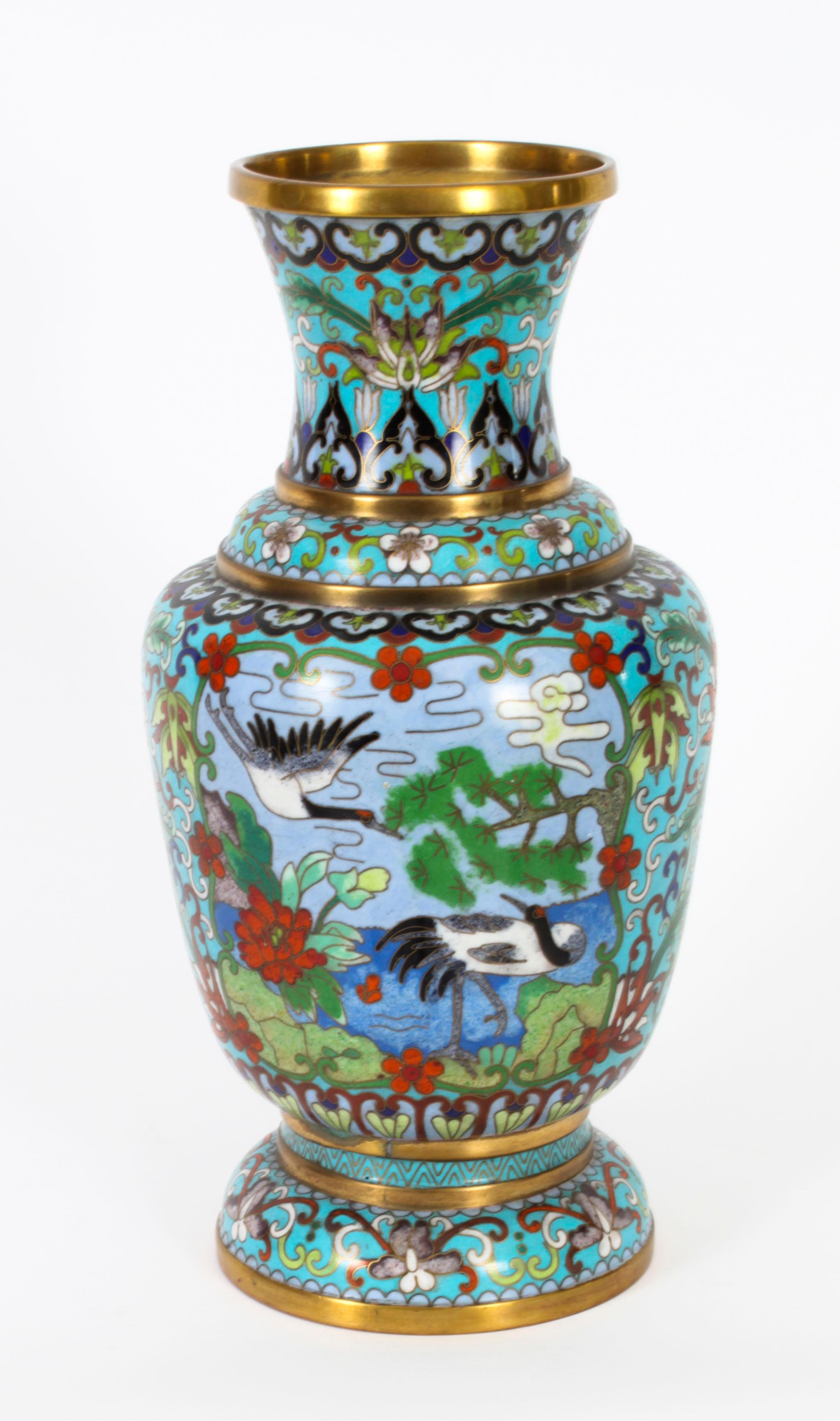 This is a large vintage pair of Chinese enamelled cloisonné vases, early 20th century in date.

The baluster shaped vases feature wonderful bright vibrant colours and tonality with an excellent aged patina.

The enamelled body has a pale blue