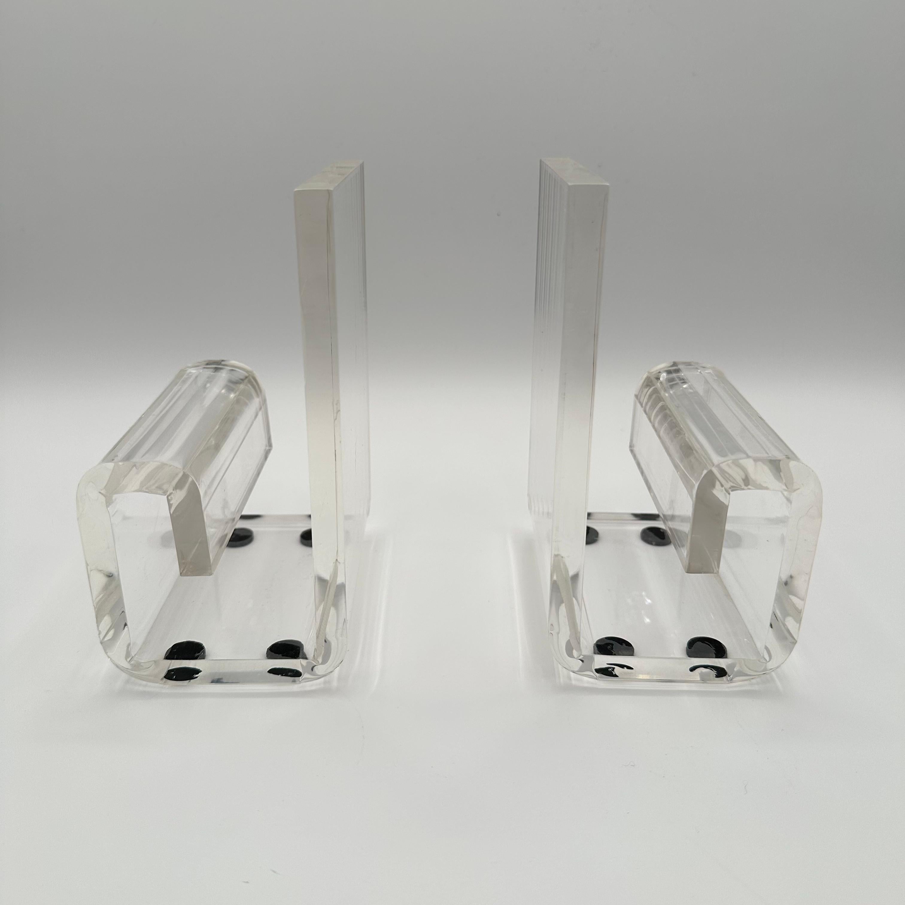 A pair of vintage lucite bookends with a chunky, curving, bracket shape, similar to the number 