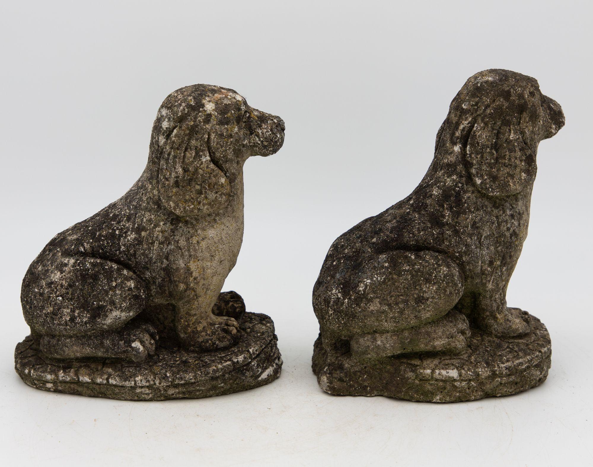 This delightful pair of mid-20th century vintage concrete spaniels is a charming addition to any garden or interior space. Playfully perched on a stone, these small sculptures capture the joyful spirit of these beloved canine companions. With wear